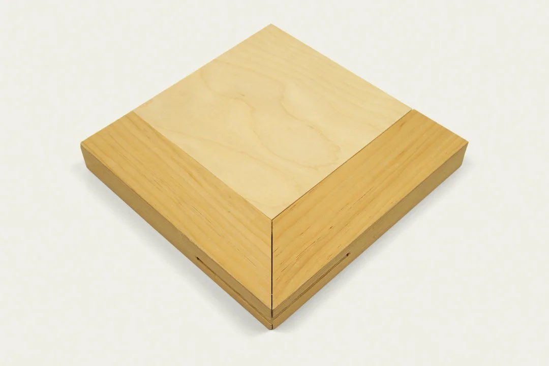A wooden square box with a lid, made of light-colored wood.