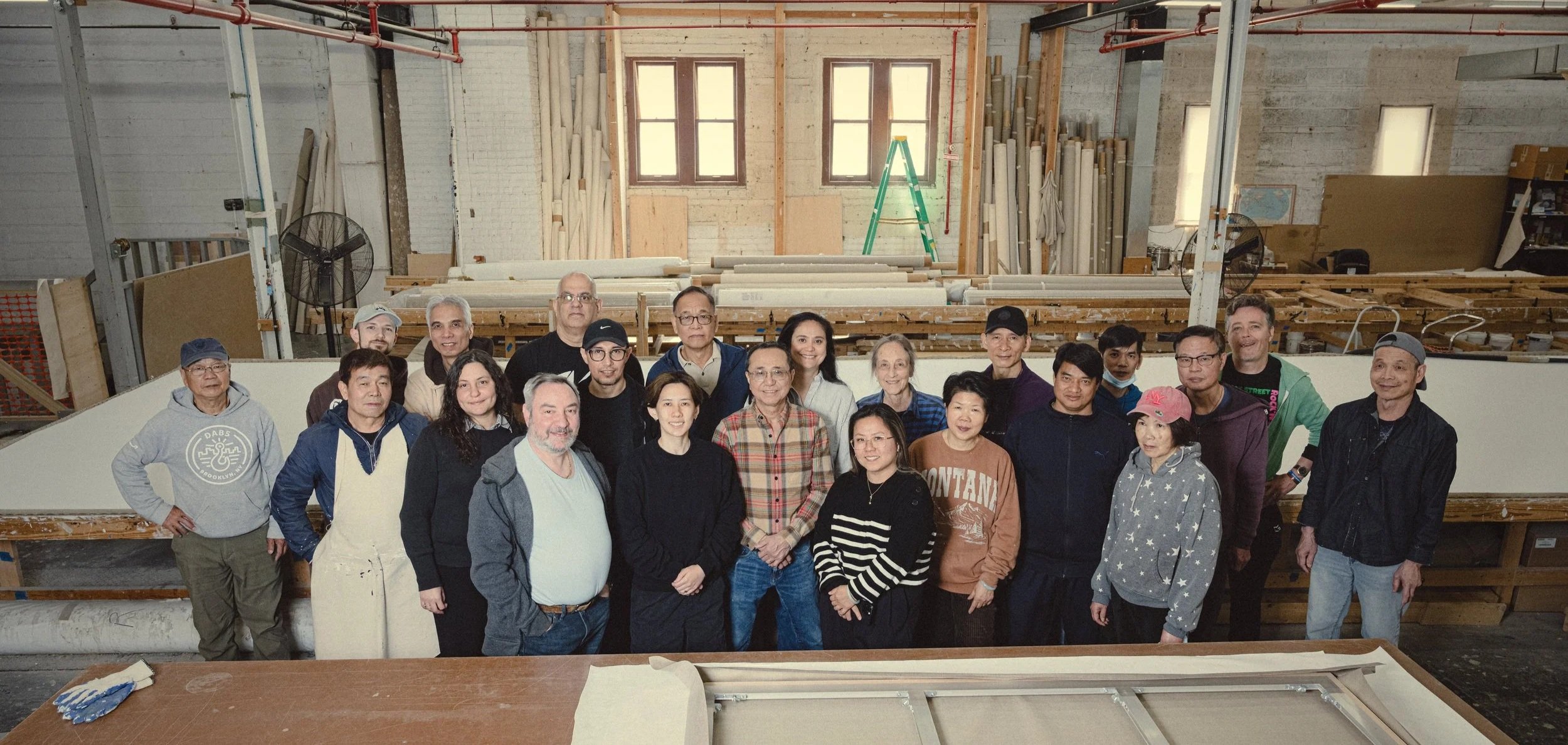 Simon Liu, Inc. team in their Brooklyn shop surrounded by their art supports.