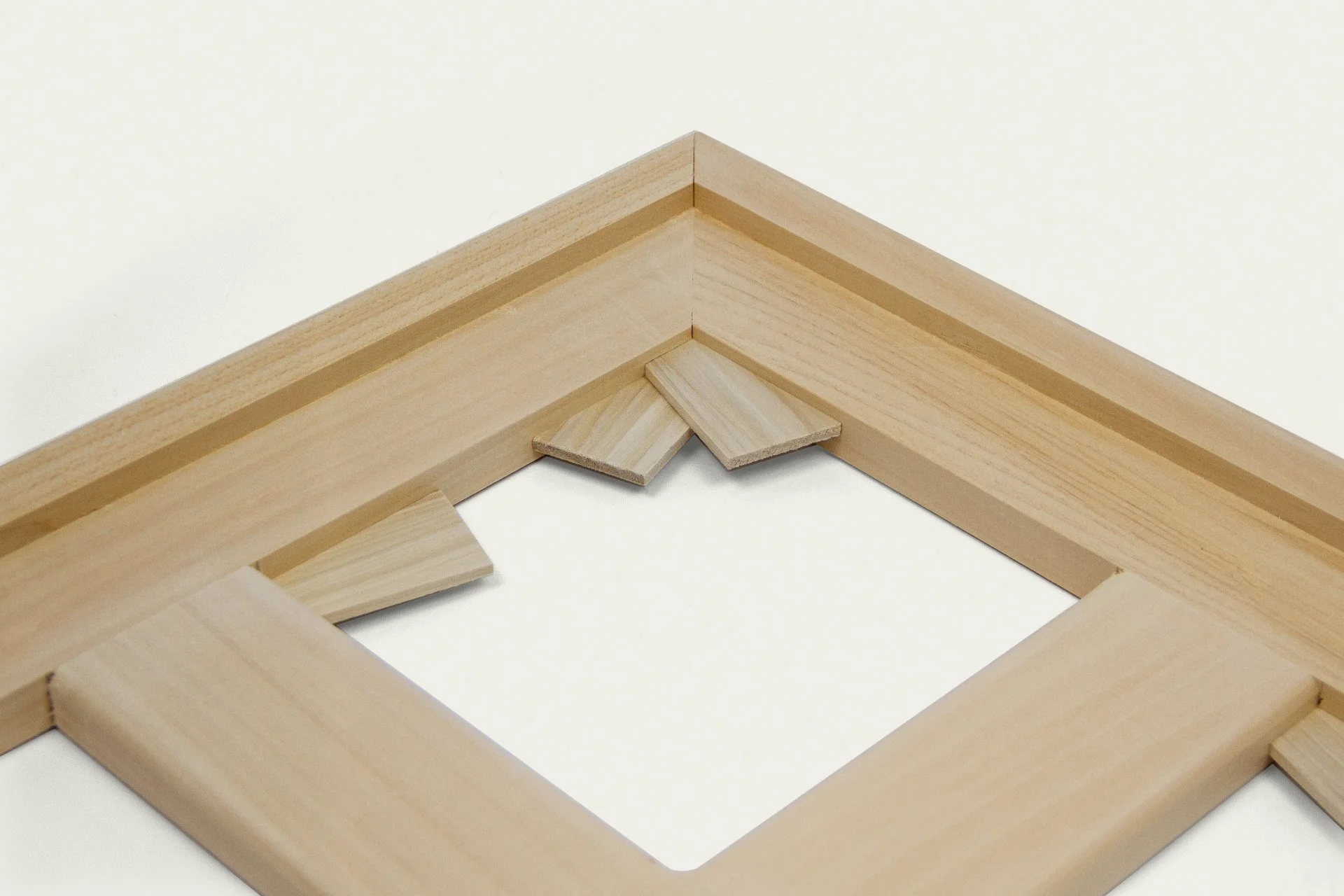 Close-up of a wooden picture frame corner with miter joint and inlay pieces