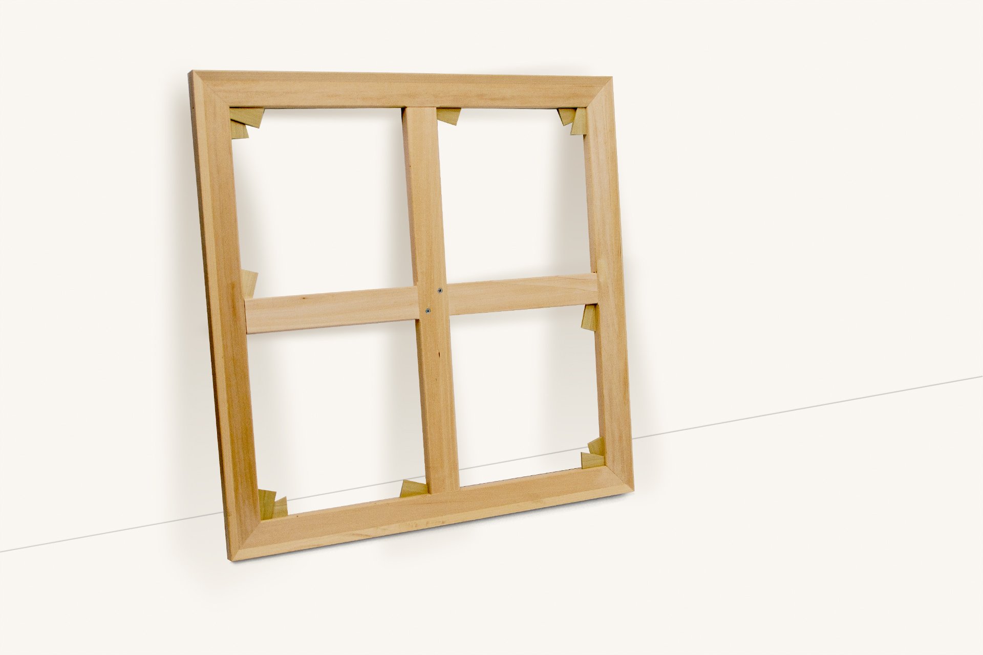 Empty wooden canvas frame propped against a white wall.