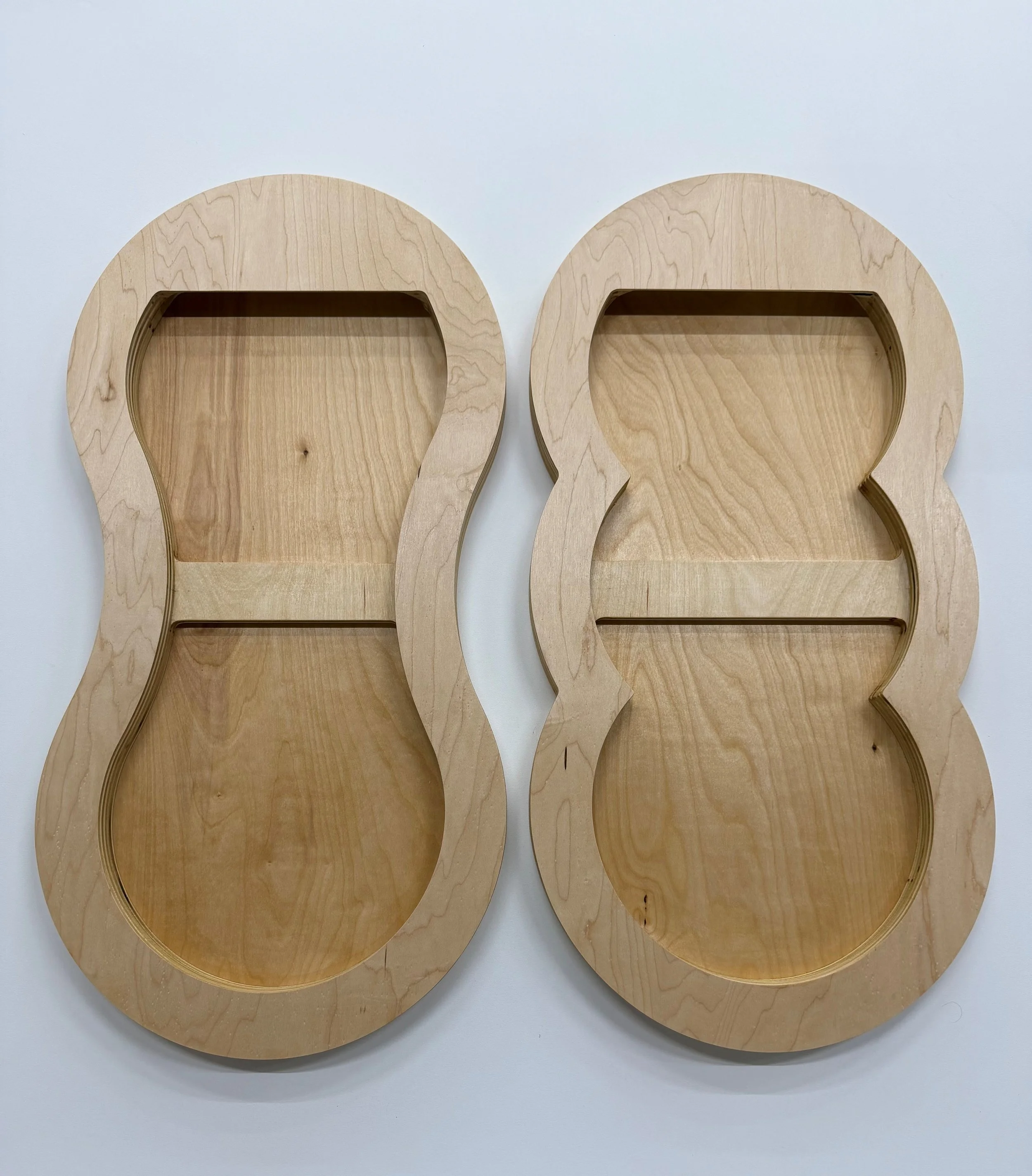 Two wooden shaped art panels made by Simon Liu, Inc. custom-made and designed, placed on a white surface.