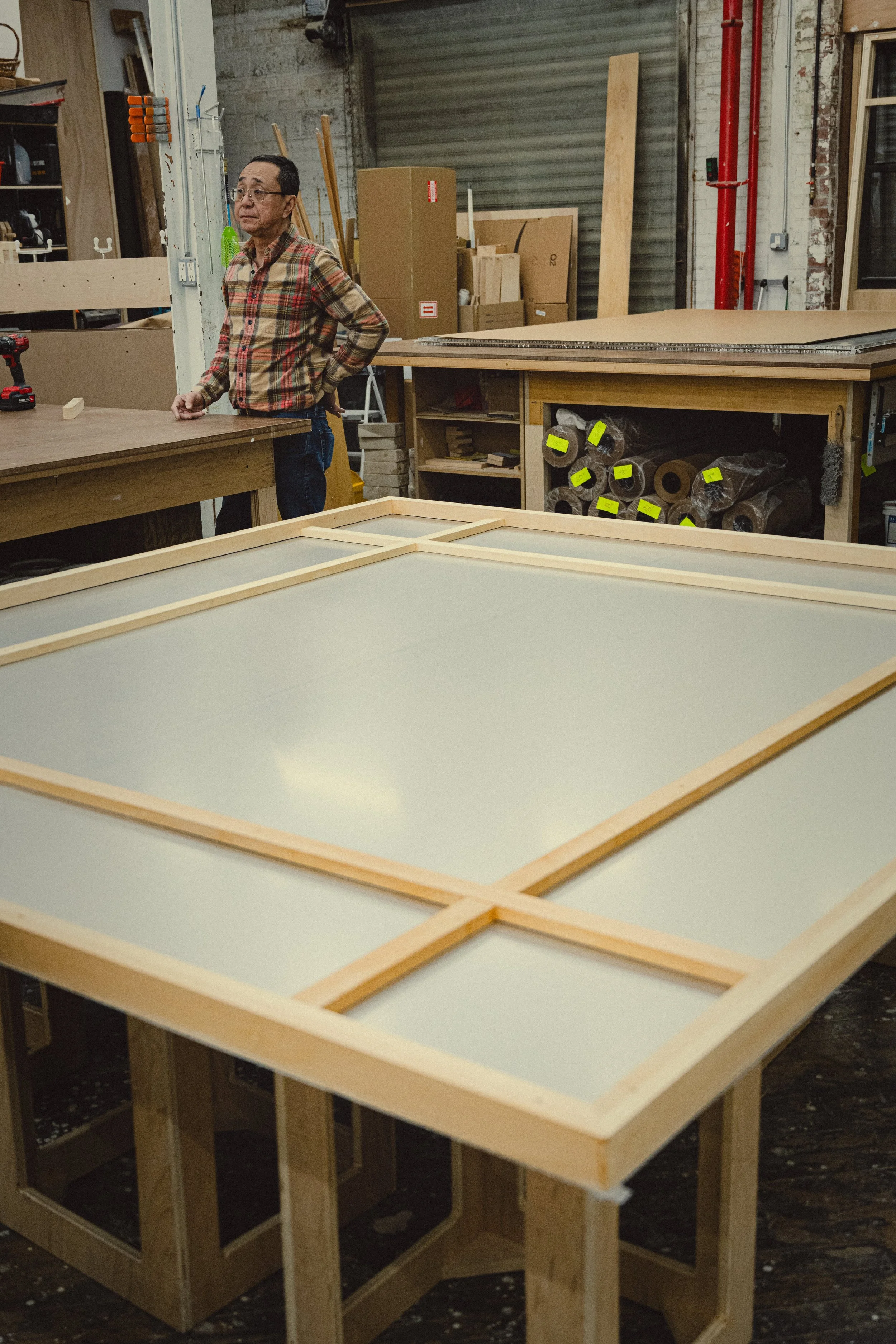 An aluminum honeycomb panel being finished with a wooden cradle and edge treatment at Simon Liu, Inc.