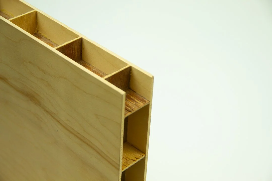 Close-up of a wooden box with multiple compartments against a plain light background.