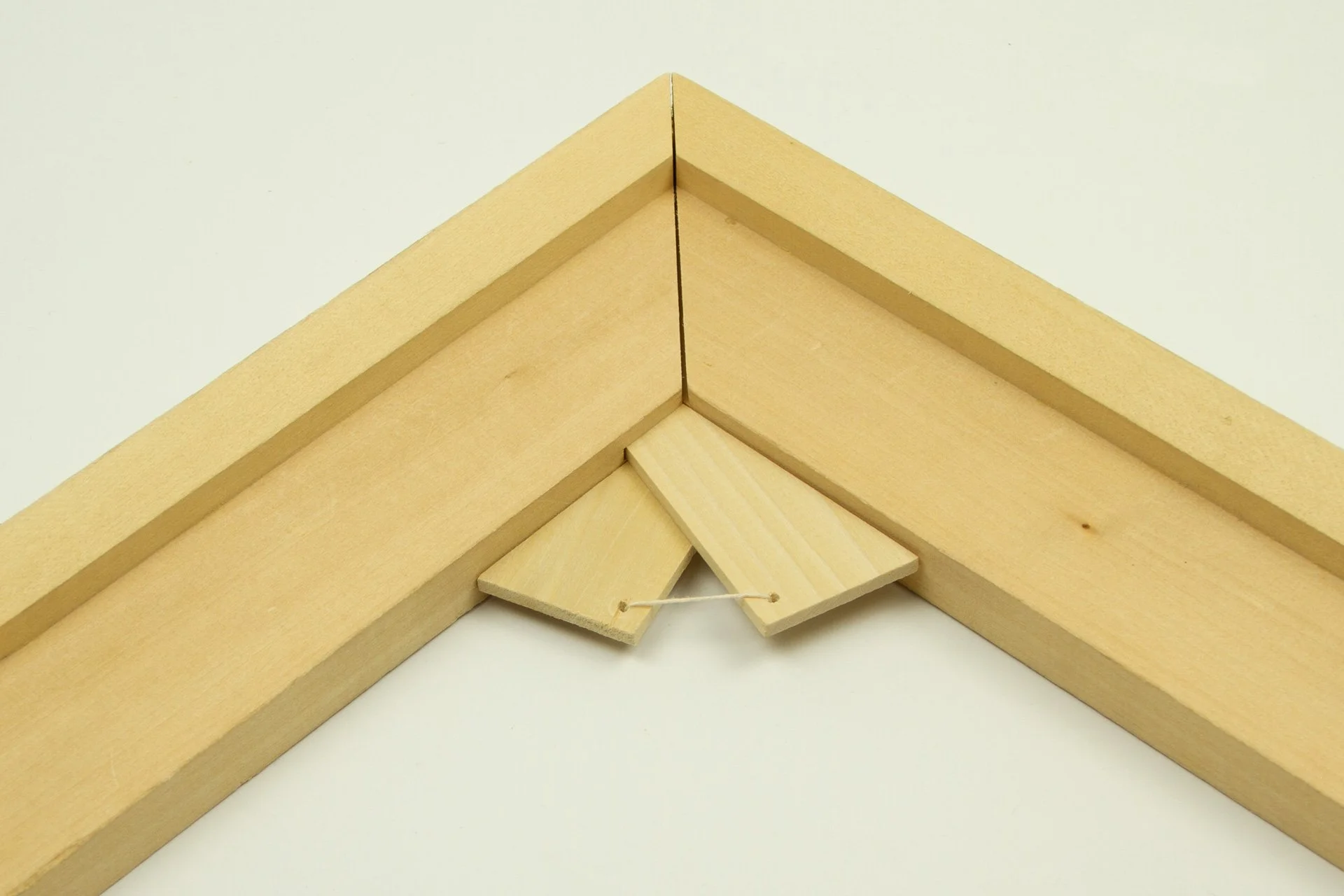 Wooden corner piece with two small inset wooden keys connected by a string.