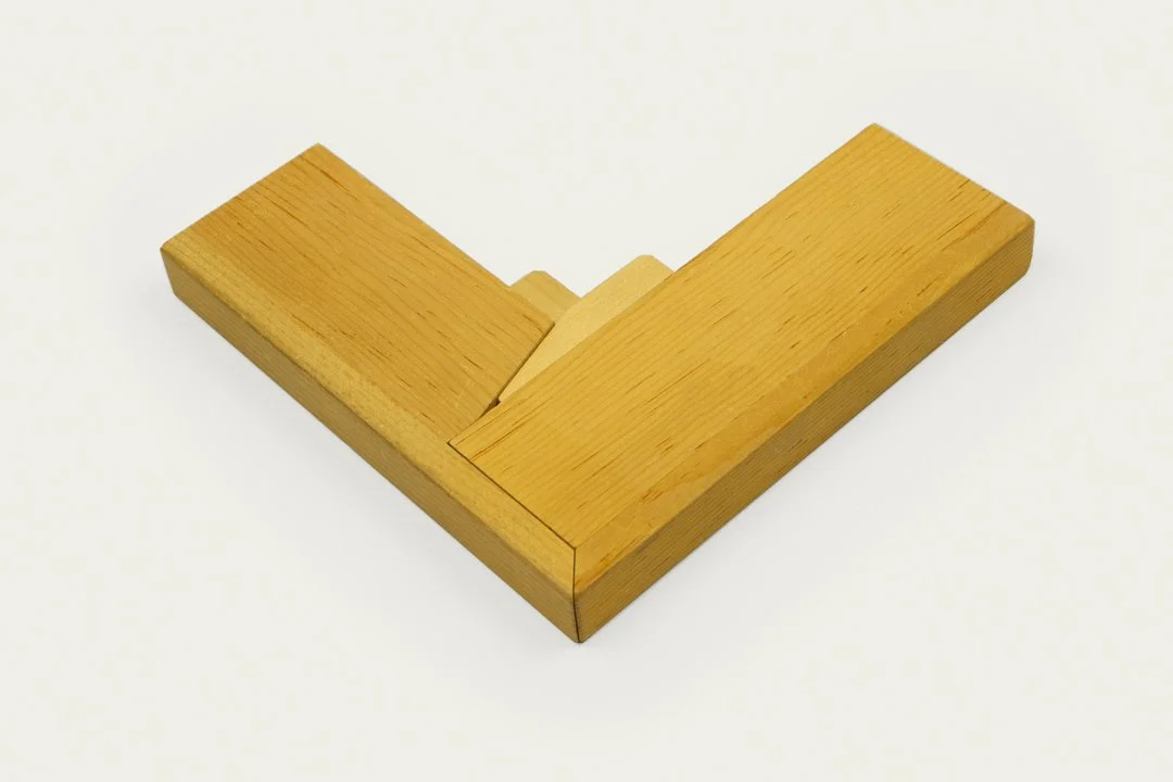 A wooden puzzle consisting of interlocking pieces arranged in a V-shape on a white surface.