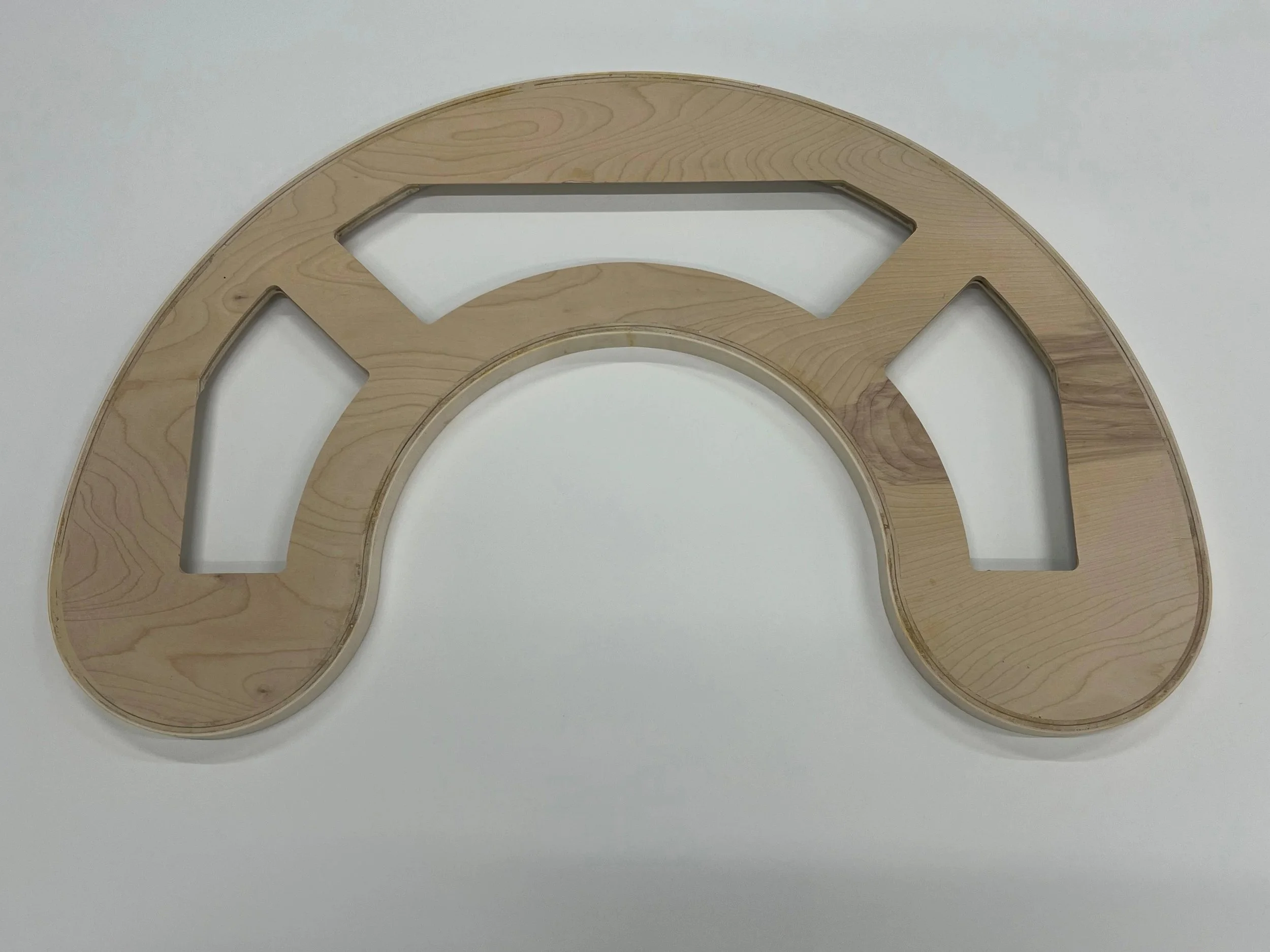 Wooden circular decorative piece with cutouts, placed on a white surface.