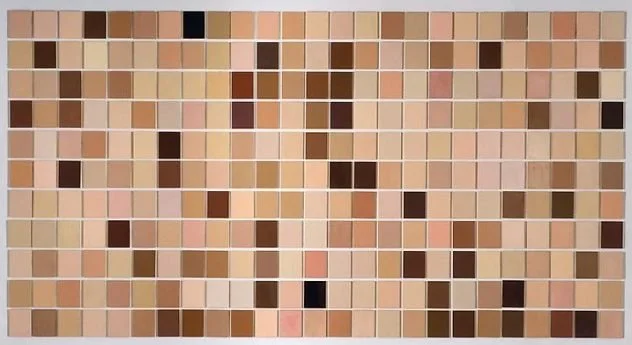 A mosaic composed of small square tiles in various shades of beige, brown, peach, and black arranged in a grid.