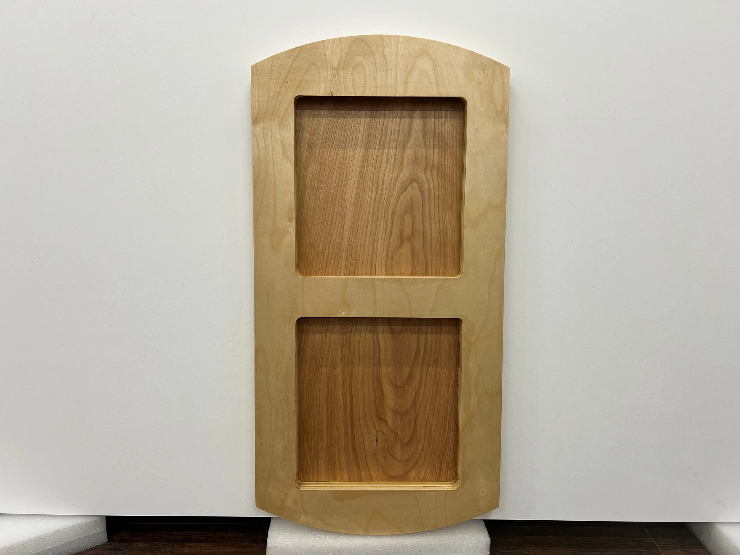 A wooden wall-mount letterboard with two rectangular compartments, the top one larger than the bottom, mounted on a plain wall.