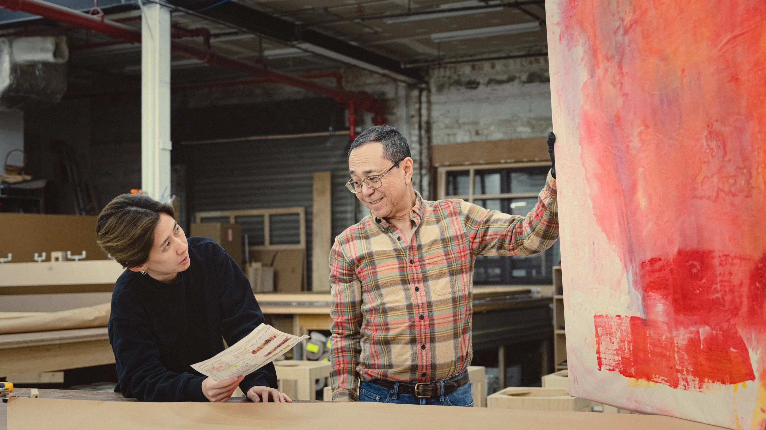 Examining a painting being stretched at Simon Liu, Inc.