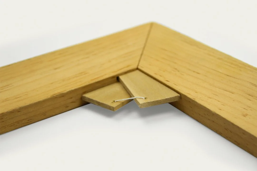 Close-up of tied keys for an art stretcher of a larger wooden stretcher.
