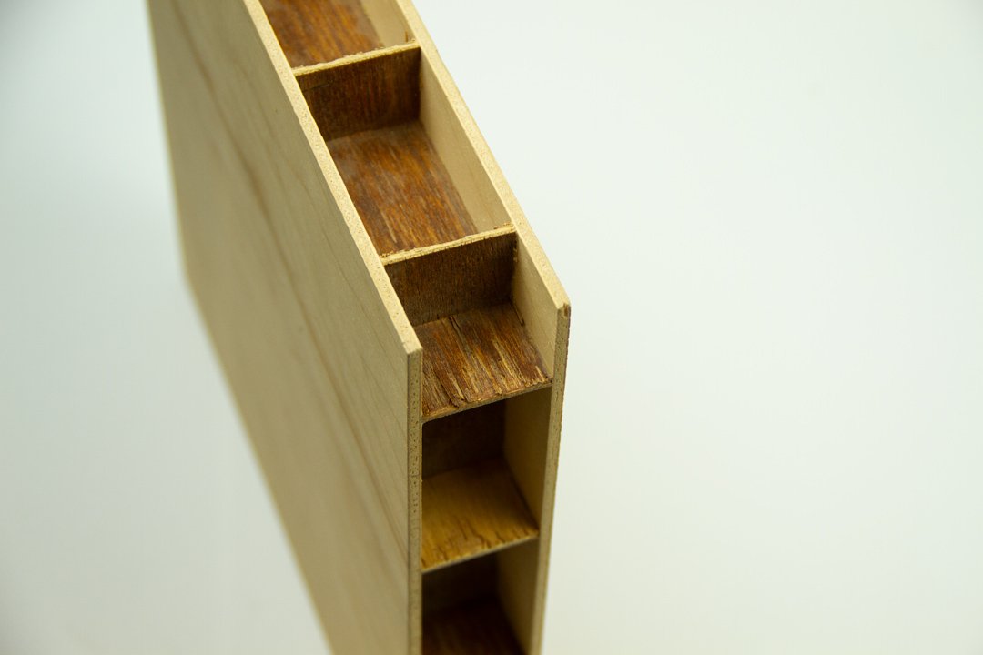 Close-up of a wooden step stool with four steps, showing the interior and side view.