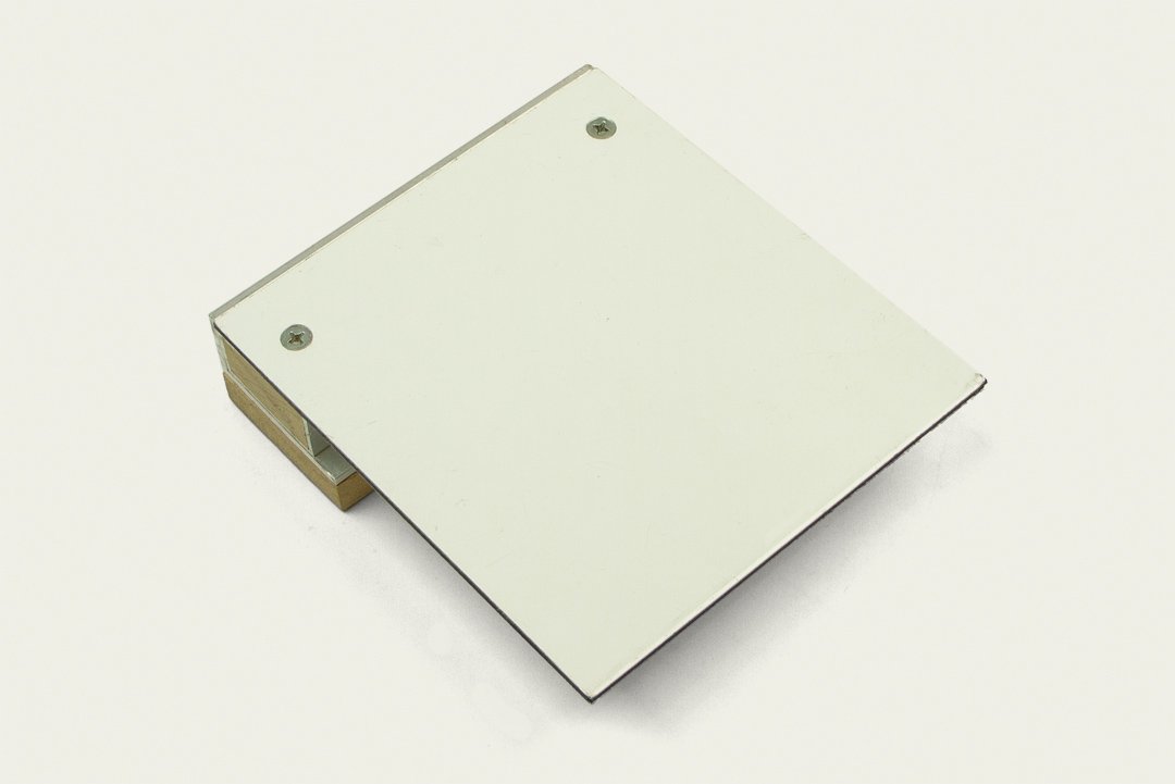 A square-shaped mirror with a plain white surface and three metal screws securing it, resting on a white background.