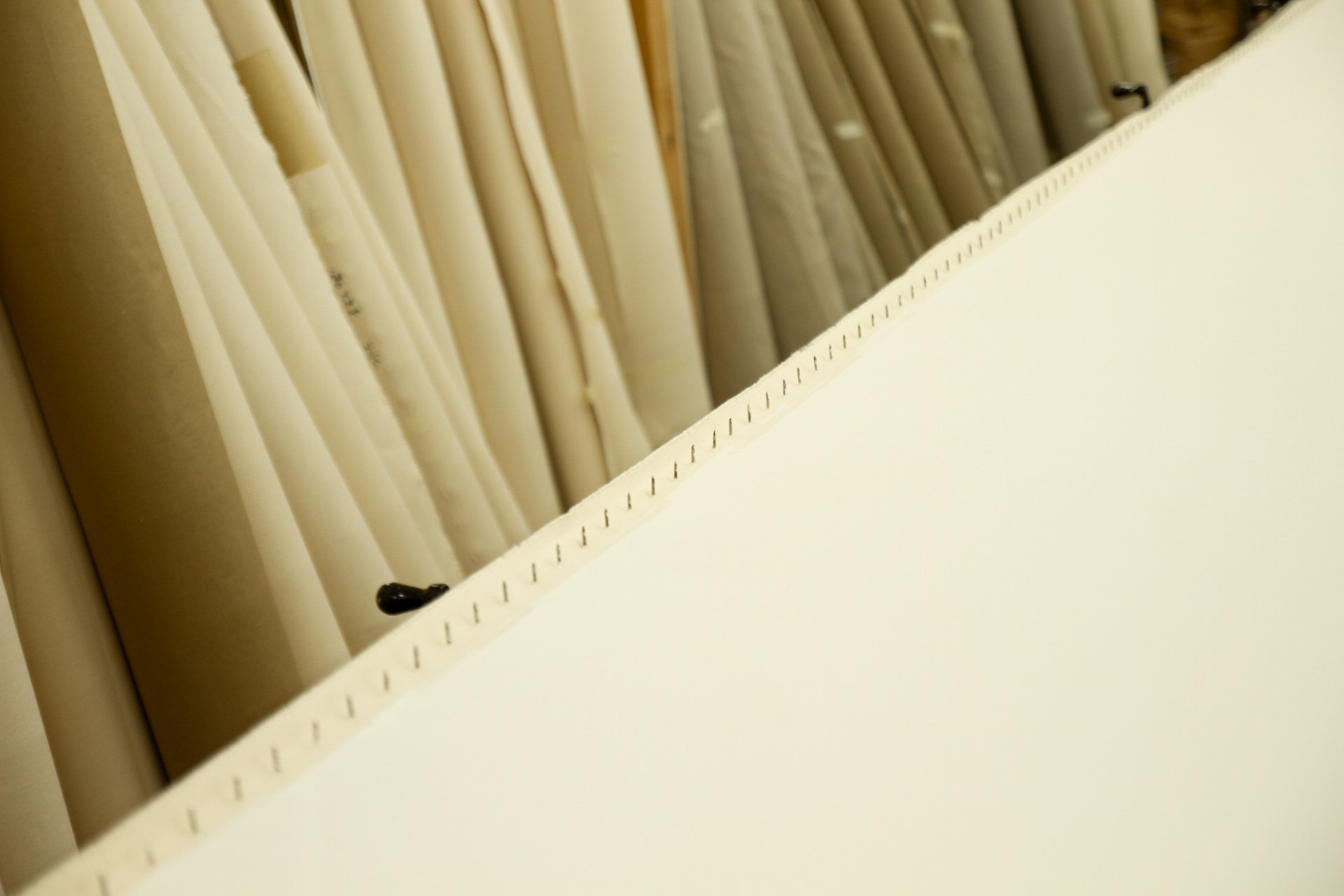 Rows of rolled fine canvas and linen pre-gessoed.