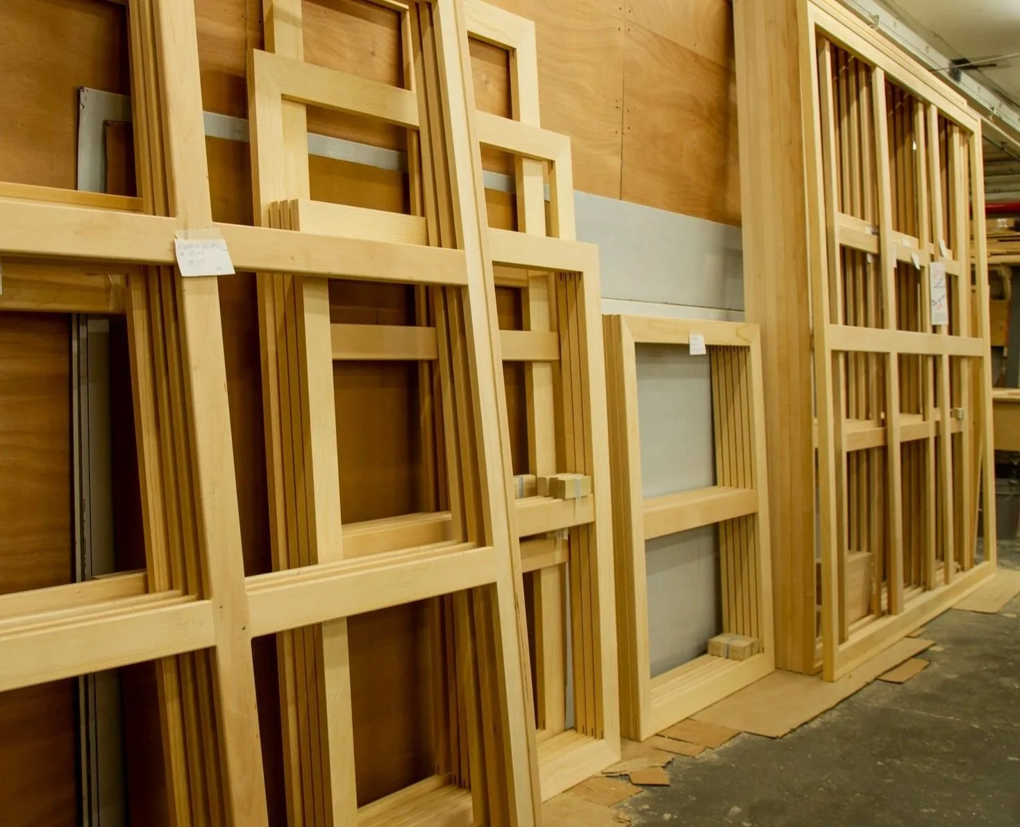 Wooden American Traditional art stretchers stacked vertically in a woodworking shop.