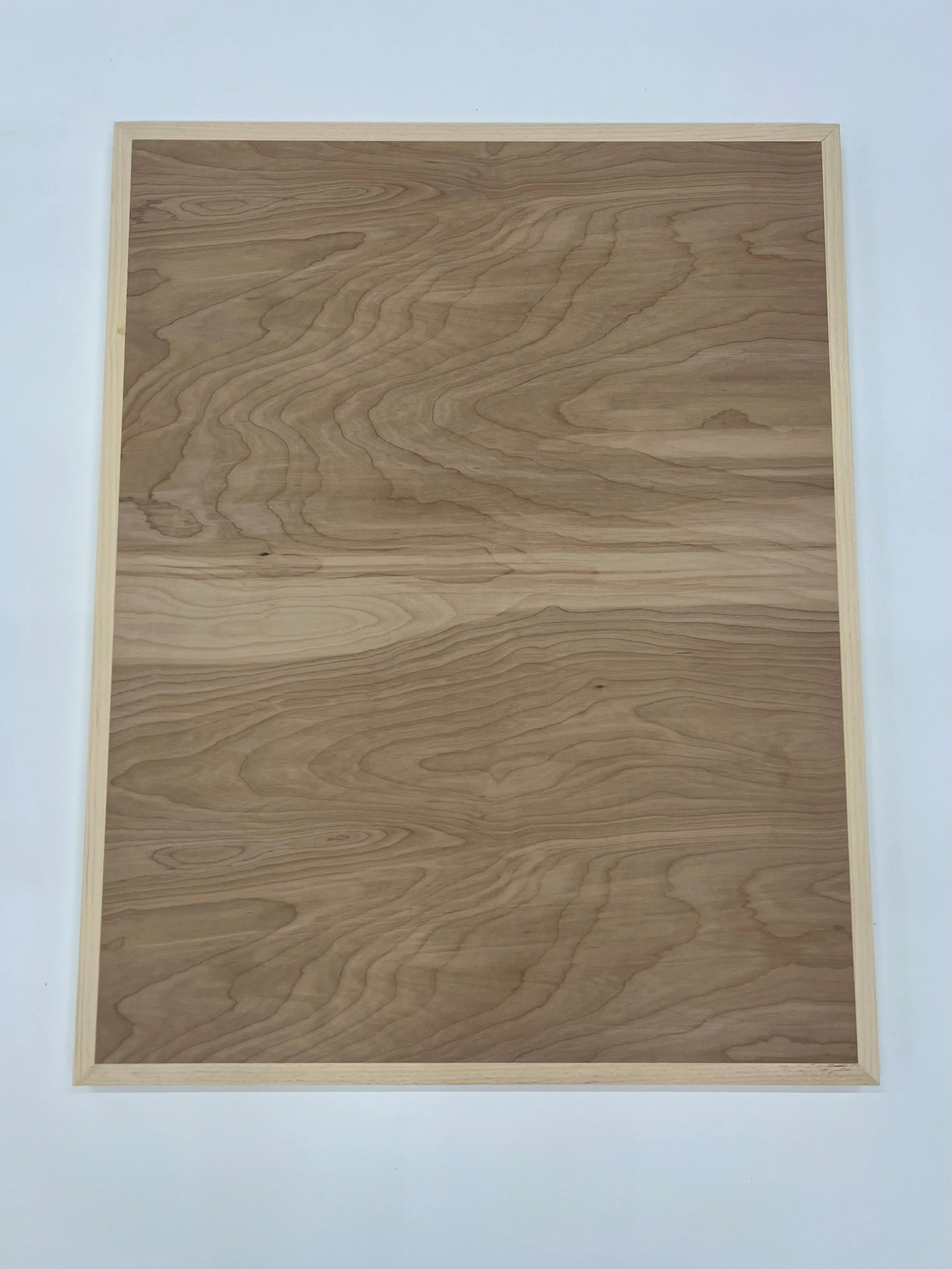 Close-up of a wooden keyable art panel with natural grain patterns and a light wooden edge.