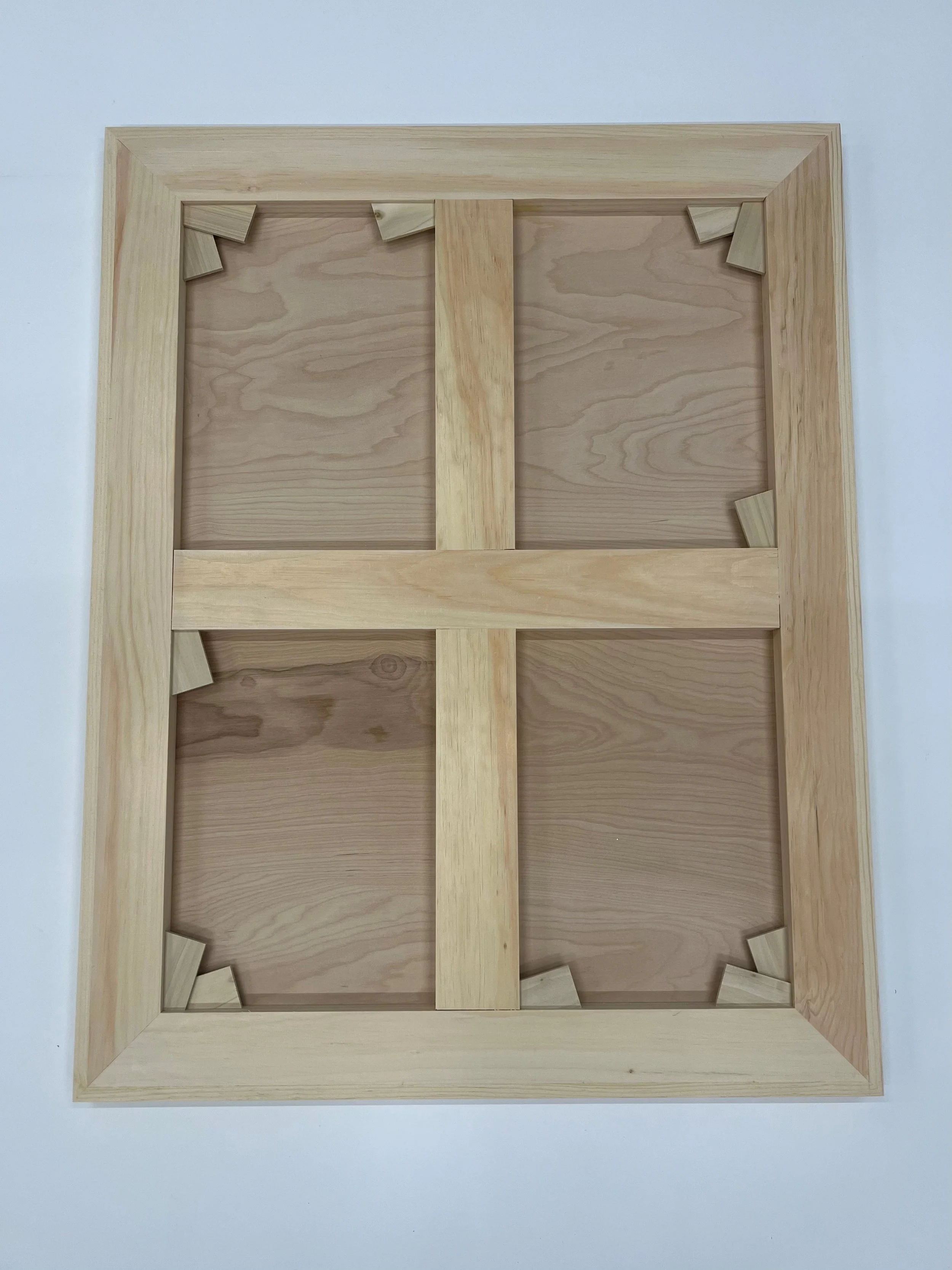 Wooden keyable panel with mitered corners, inserted keys, and cross supports on a white surface.