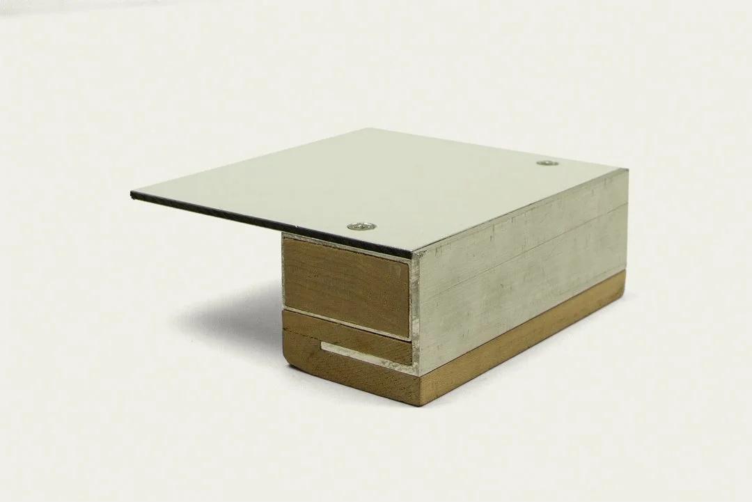 A small woodworking clamp with a metal top, wooden sides, and a brown wooden base.