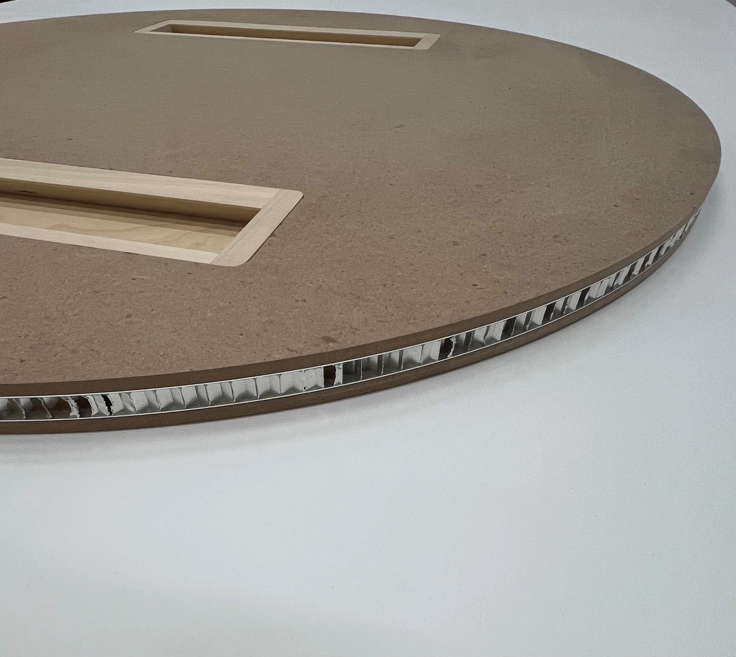Close-up of aluminum honeycomb panel with an exposed core sandwiched with MDF material with built-in hanging wall cleats.