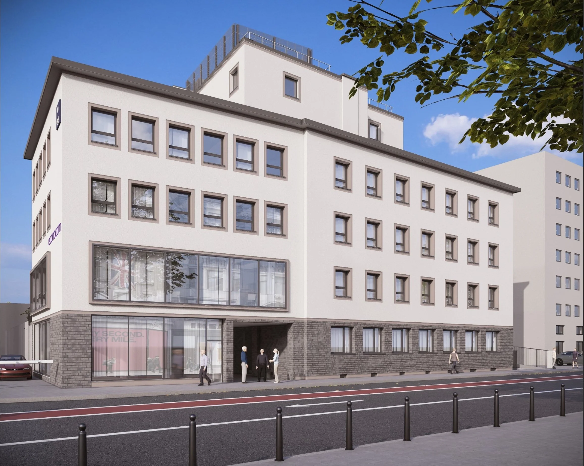 Ein modernes, weißes Mehrfamilienhaus mit großen Fenstern an einer Stadtstraße, einige Menschen gehen vorbei, Bäume und andere Gebäude im Hintergrund.