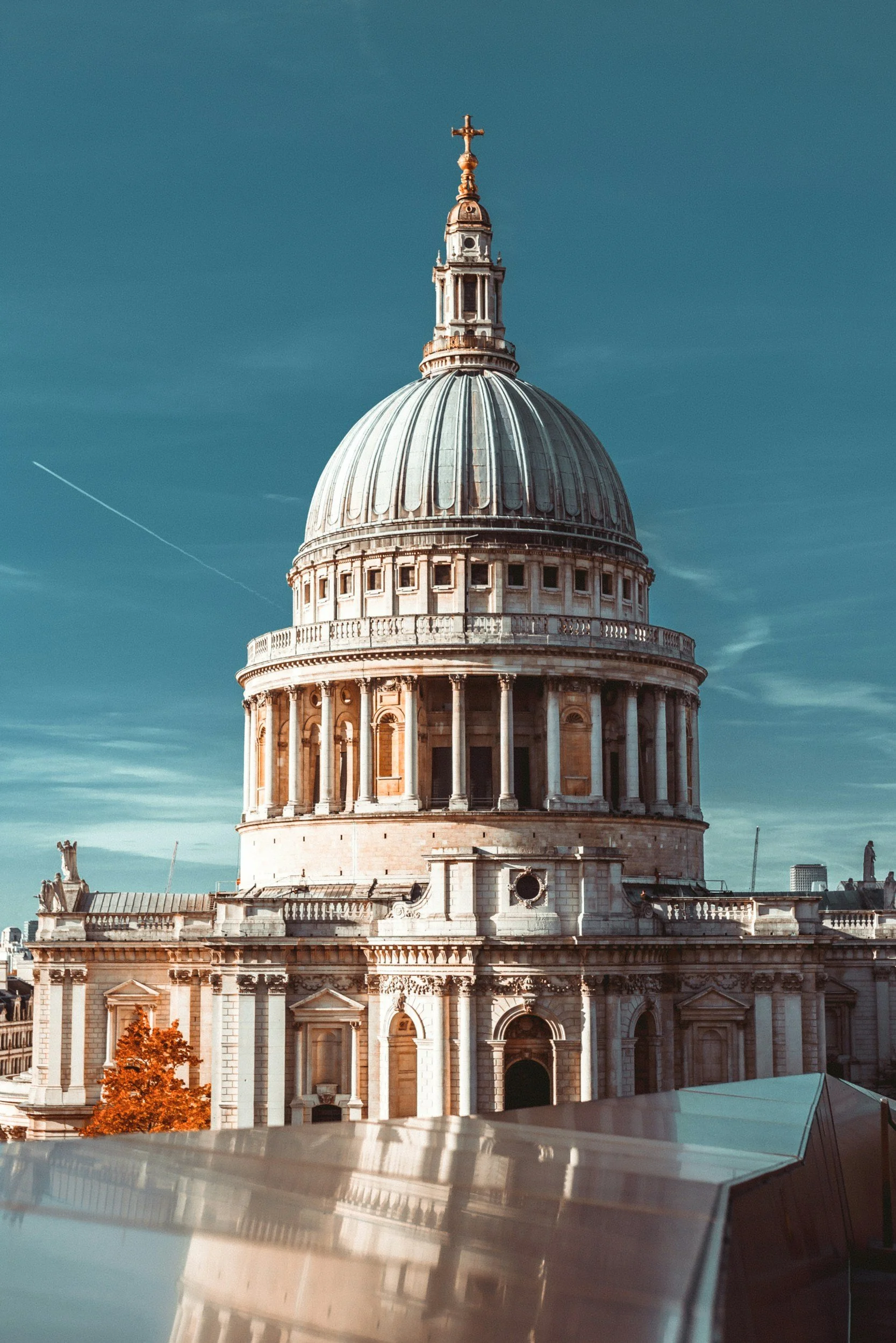 The dome and facade of St. Paul's Cathedral in London, with a clear sky background.