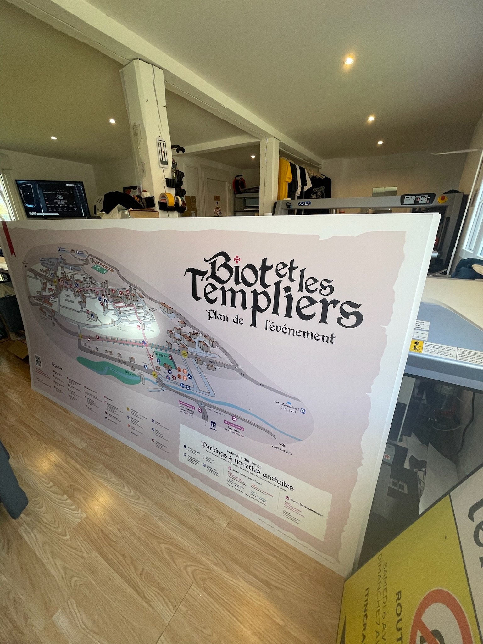 Plan de l'événement Biotibles Templier présenté sur une grande affiche dans une pièce intérieure, avec d'autres affiches ou panneaux visibles en arrière-plan.