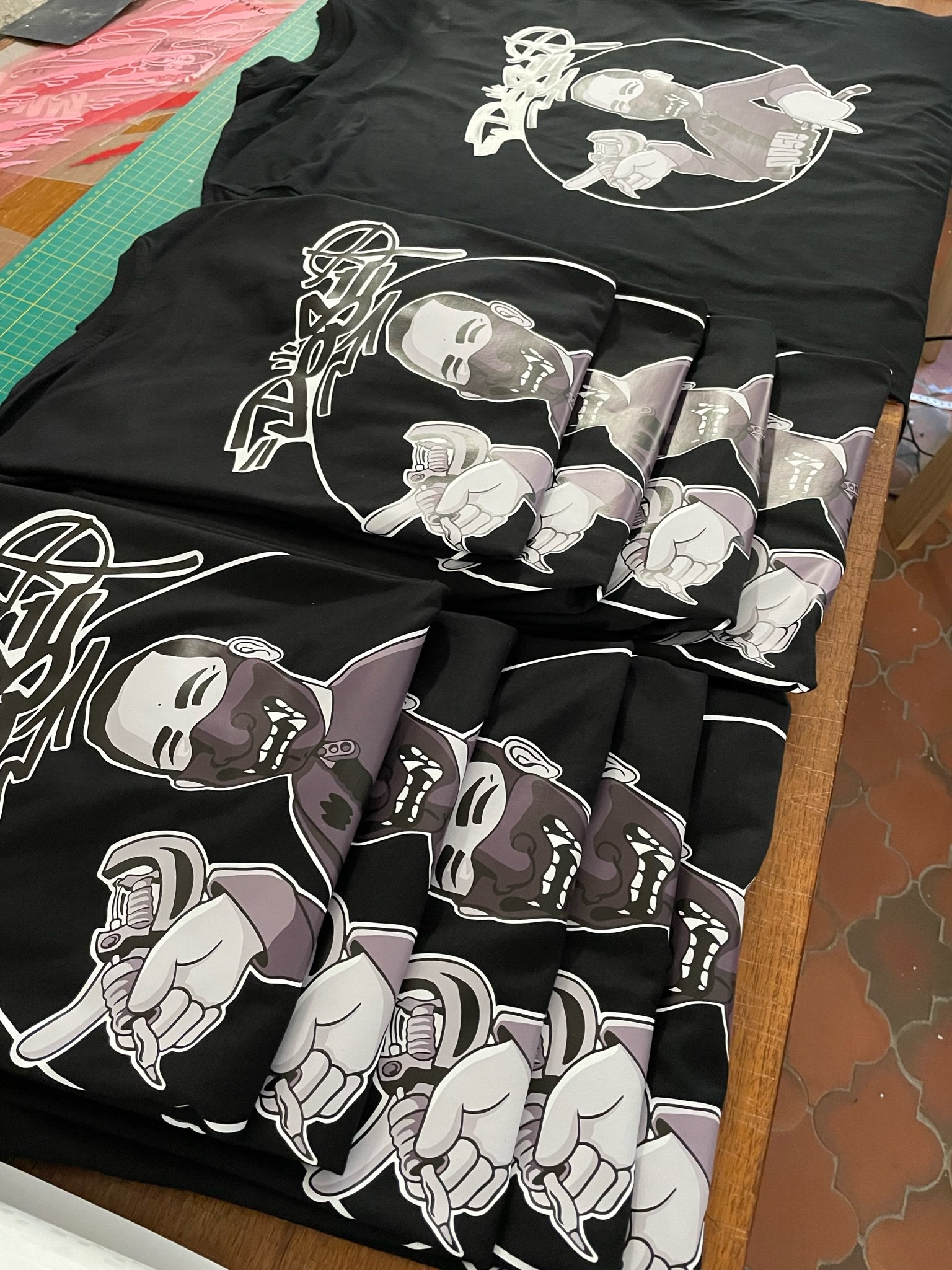 T-shirts noirs avec un design de squelette tenant une clé à molette, en style graphique.