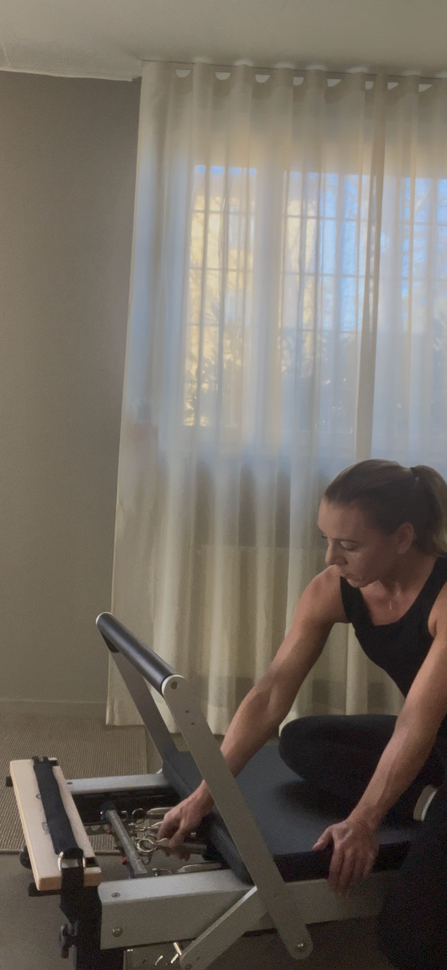 Pilatesinstruktör justerar reformer inför semi-privat pass