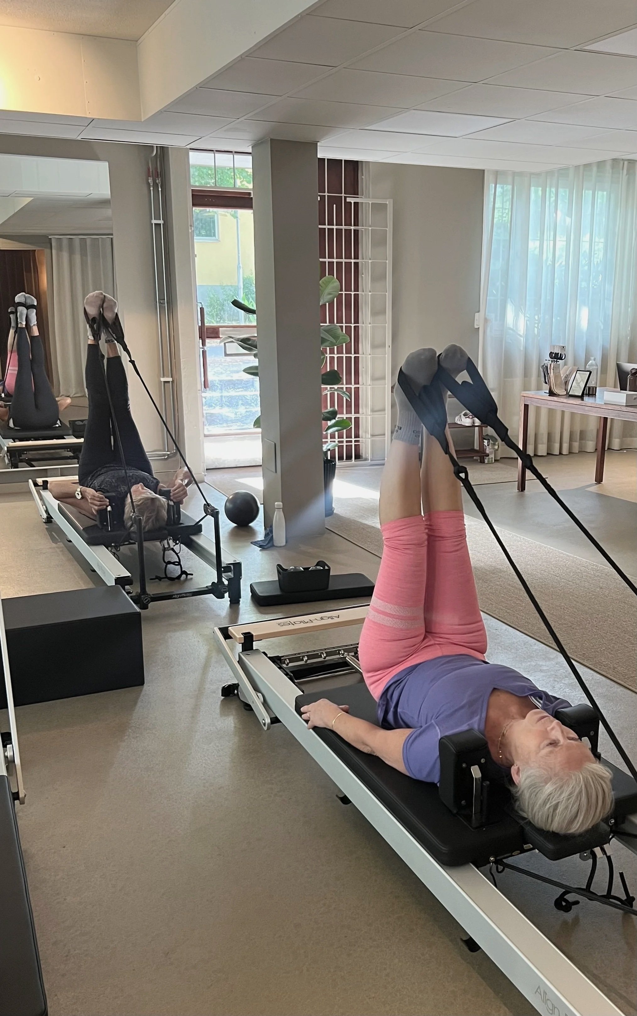 Reformer Pilates med arms in straps i kontrollerat tempo