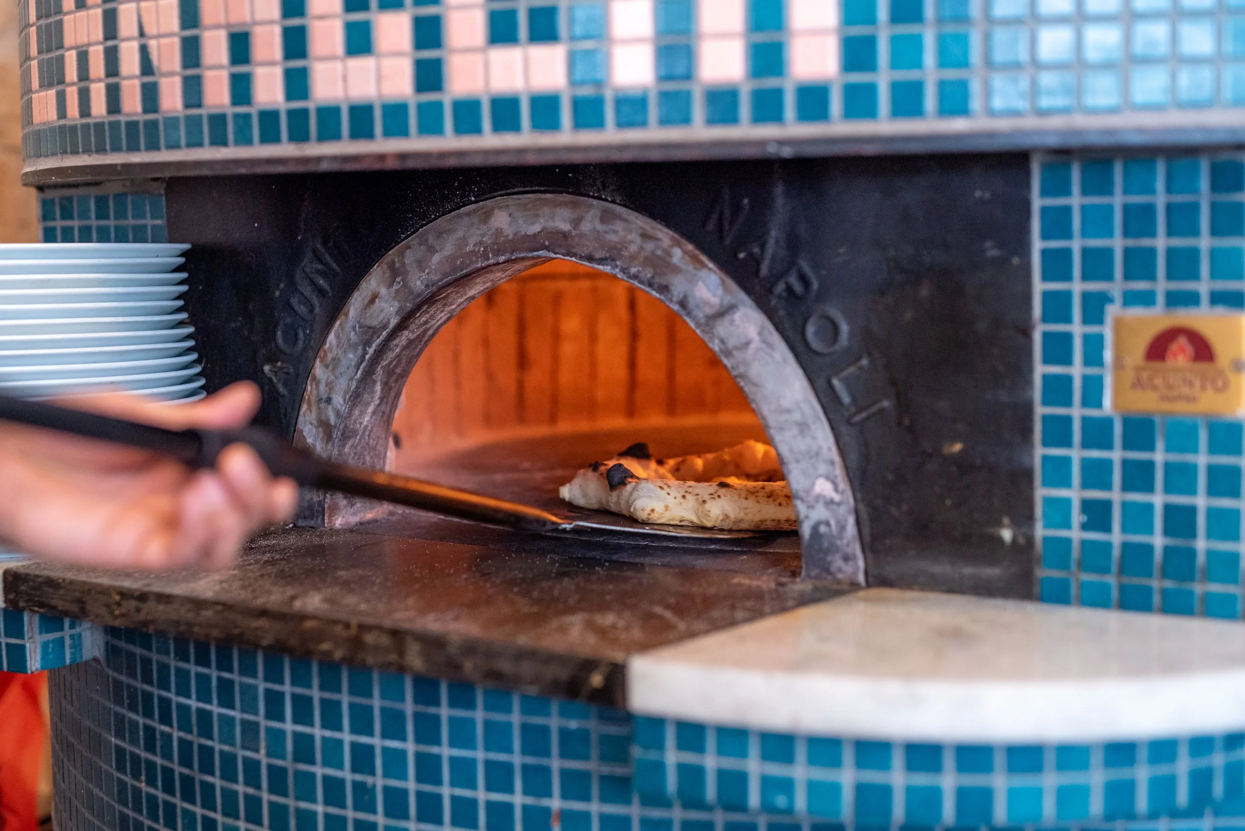 Four à pizza en fonctionnement avec une pizza qui cuit à l'intérieur.