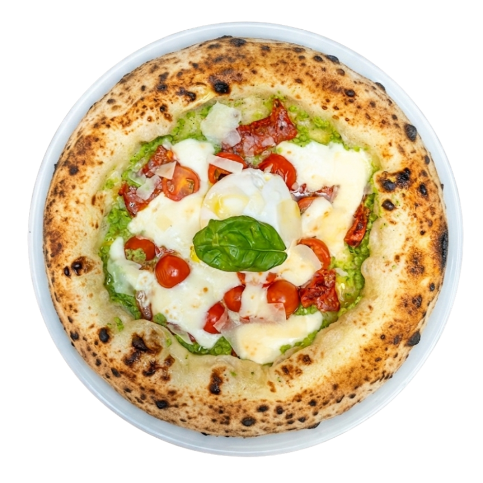 Une pizza garnie de fromage, tomates cerises, basilic, et autres légumes, avec une croûte dorée et légèrement brûlée, servie dans une assiette blanche.