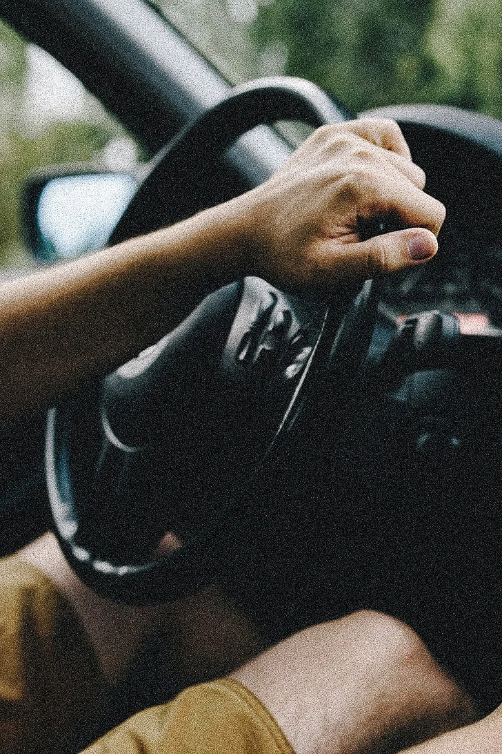 Persona conduciendo un coche, vista de la mano en el volante