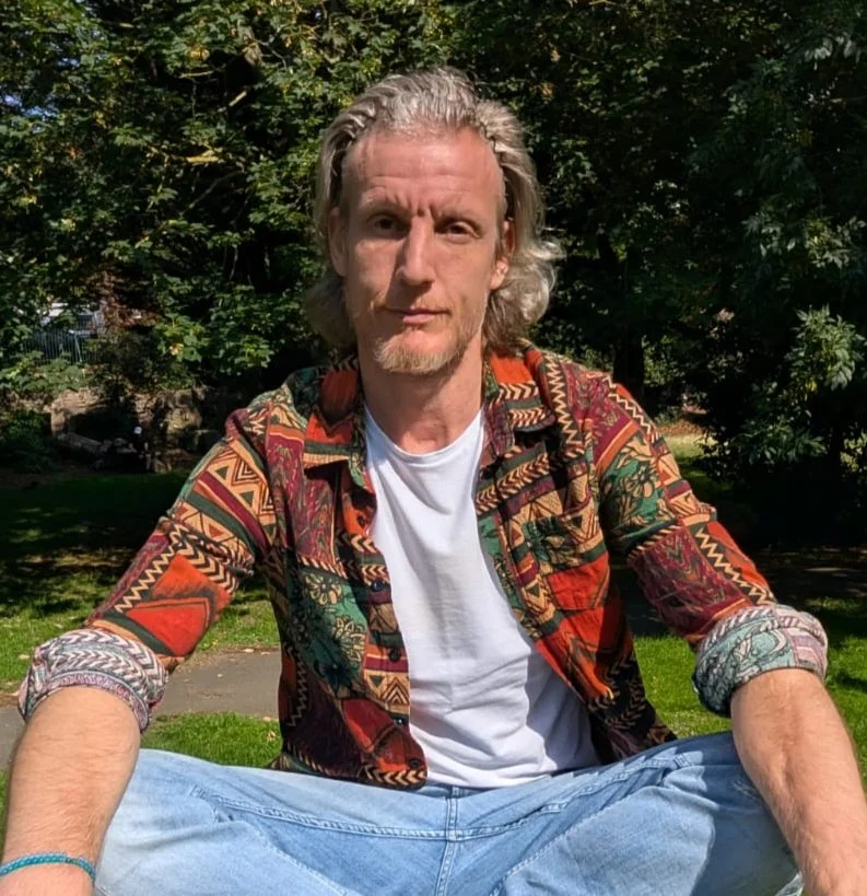 Michael Perks, kundalini energy specialist, sitting outdoors in a calm natural setting