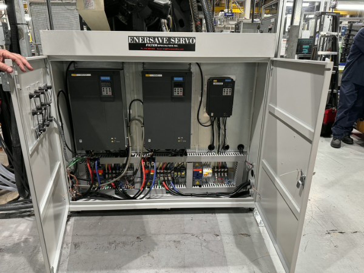 Open electrical control panel with wiring, components, and circuit boards inside.