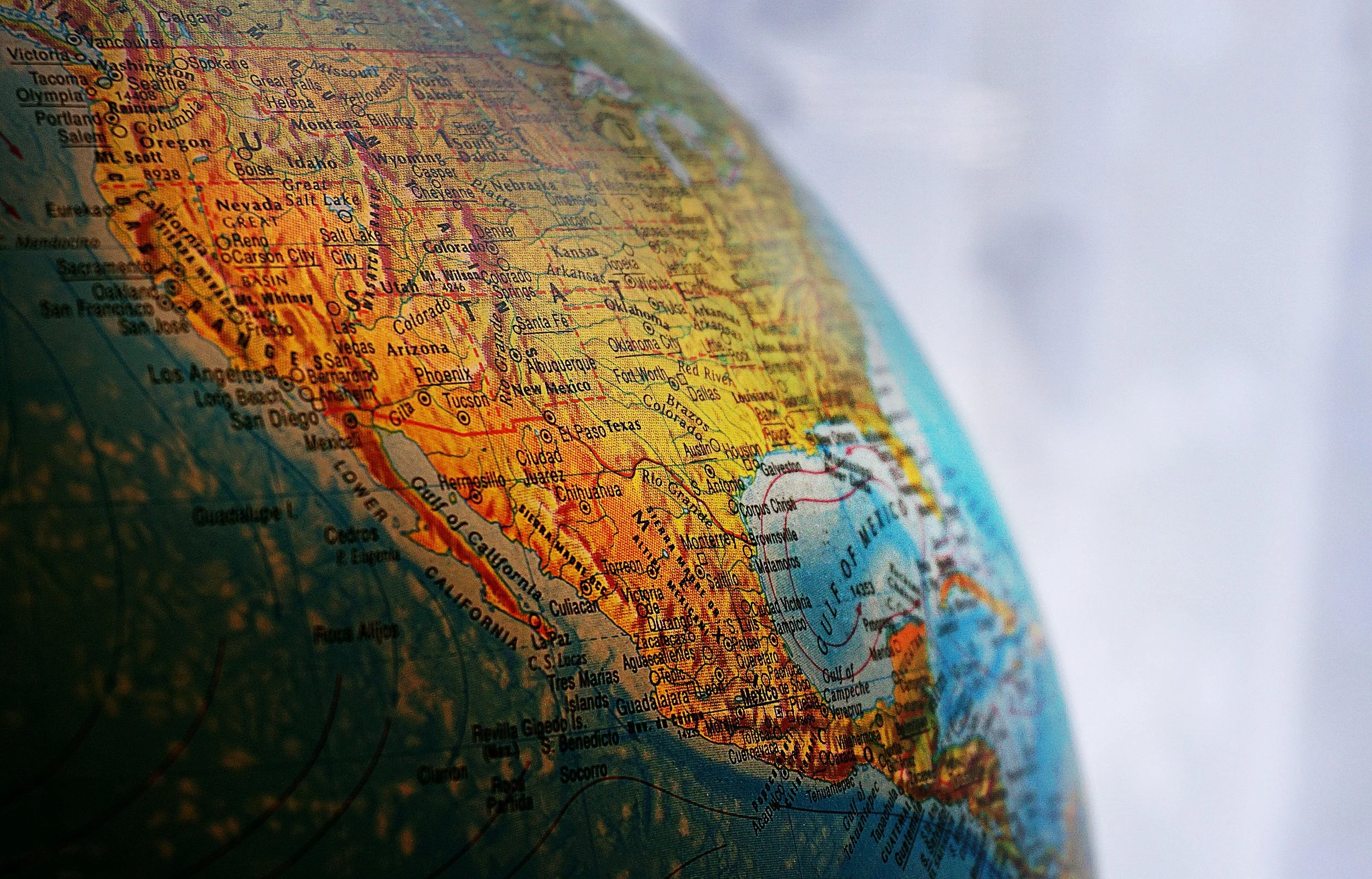 A close-up of a globe showing the western United States, including states like California, Oregon, Nevada, Utah, Arizona, New Mexico, and parts of Canada.