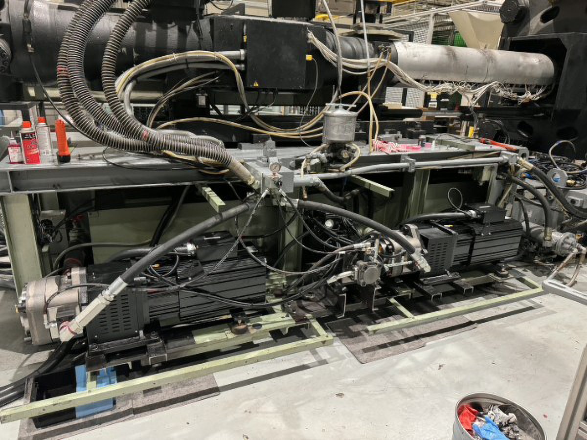 Industrial equipment with pipes, wires, and mechanical components in a factory setting.