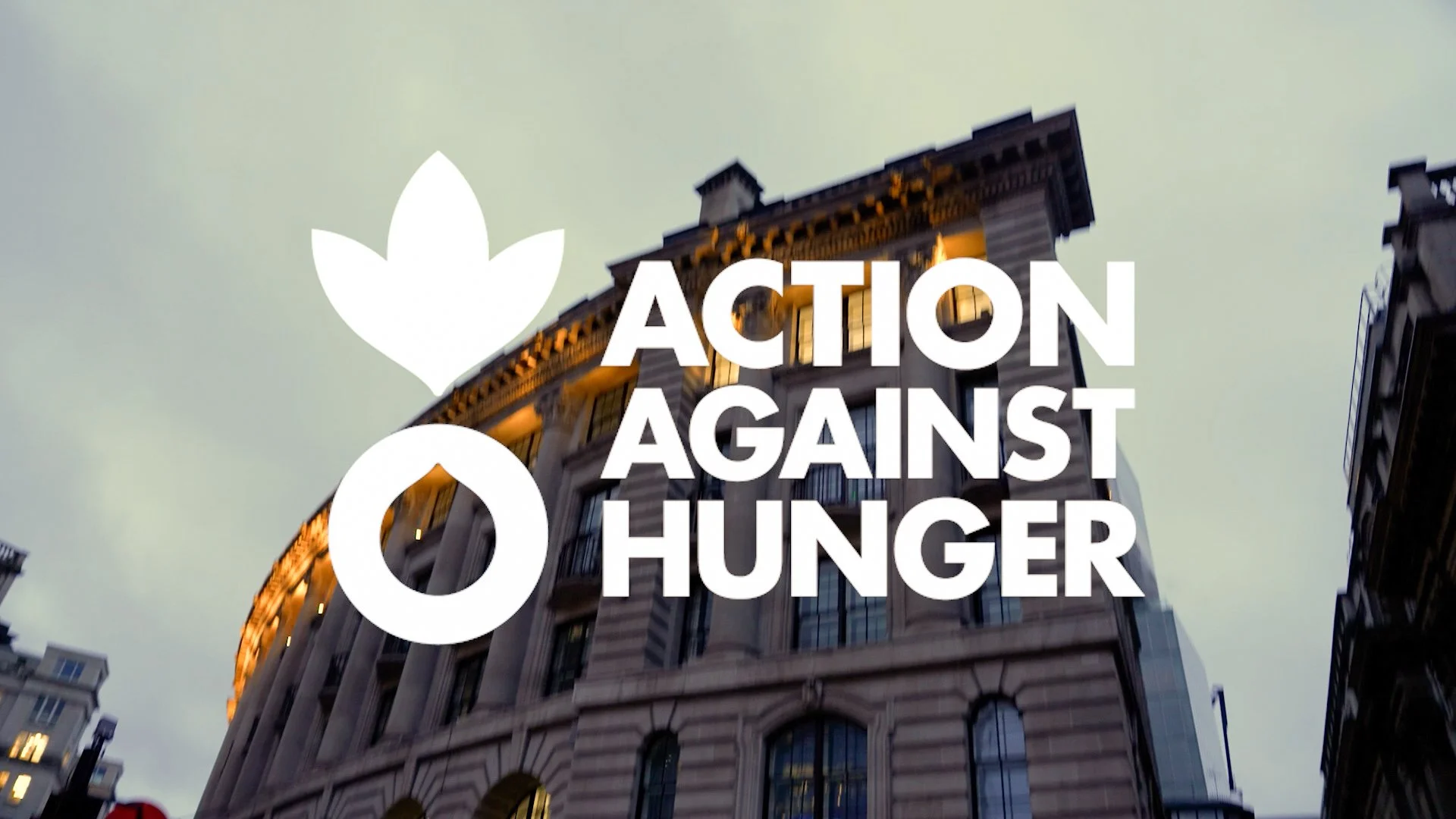 Building in an urban area with the Action Against Hunger logo and text overlay
