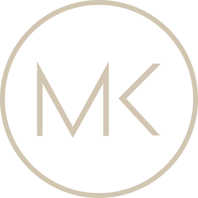 A black circular background with a beige border and the letters 'MK' in beige in the center.