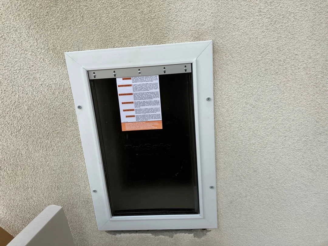 Black mail or package box installed in a wall, with a warning notice attached at the top.