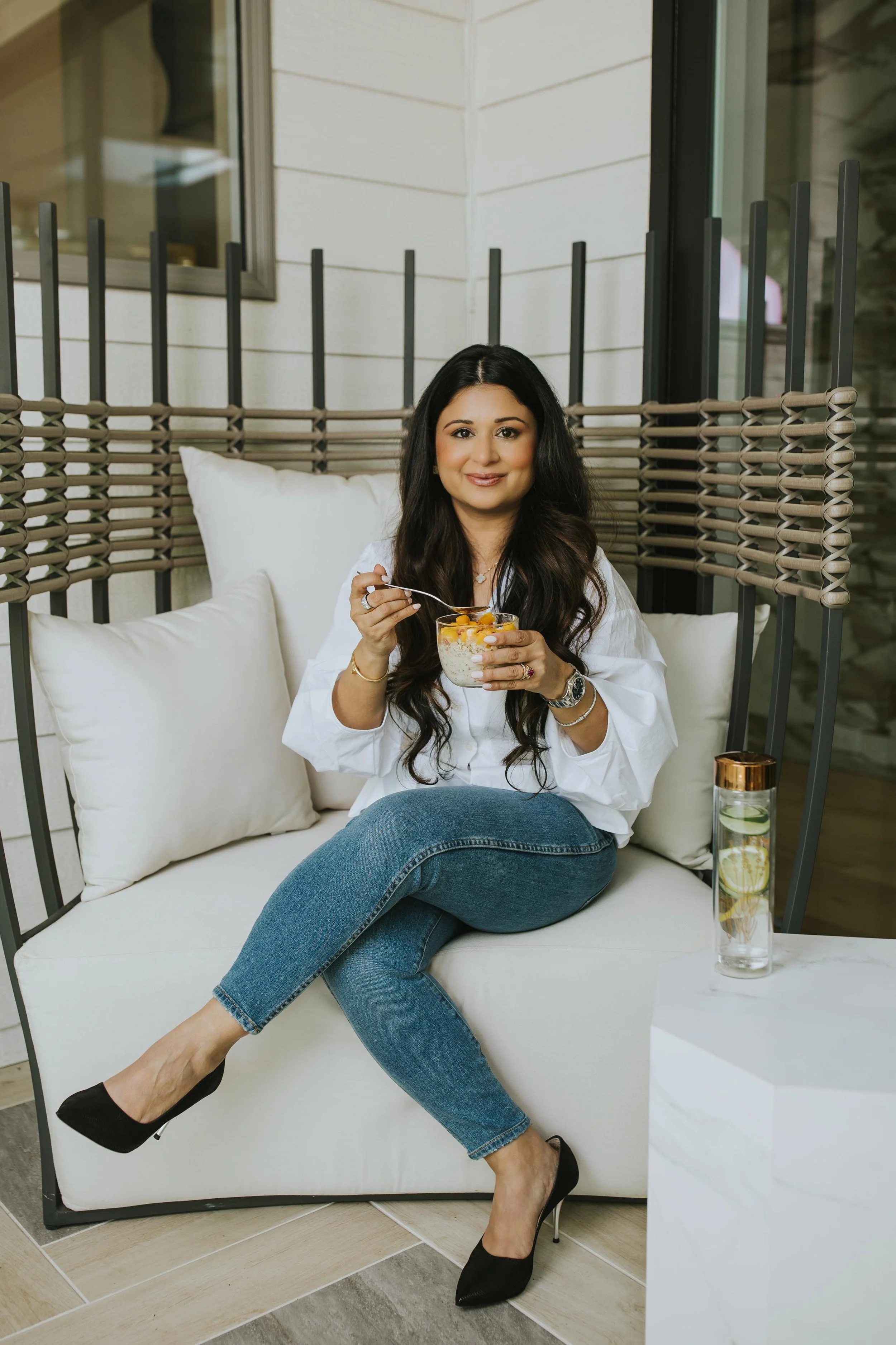 Dr. Sharma smiling at her door, holding a "namaste" poster