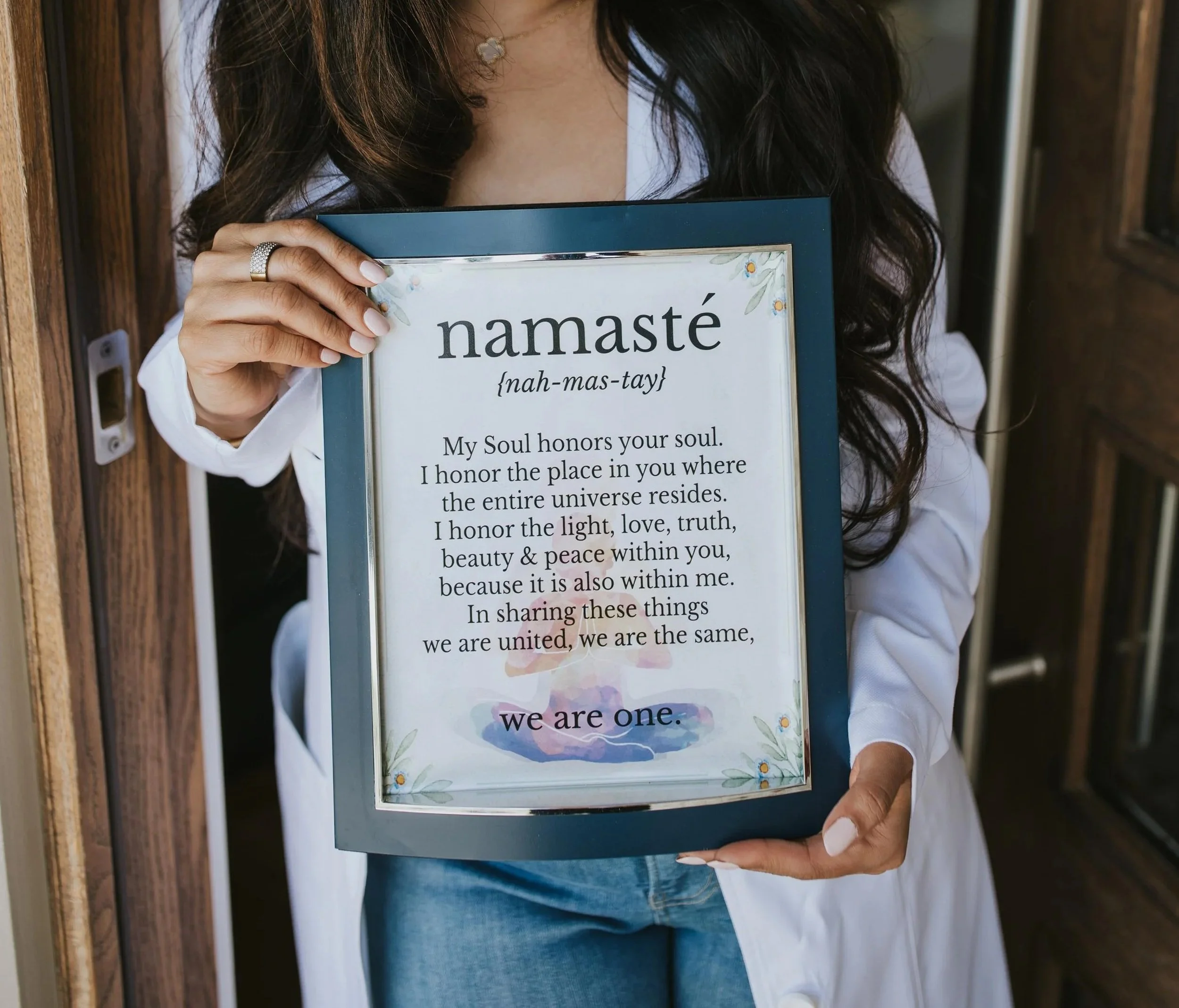 Dr. Sharma holding framed definition of "namaste"