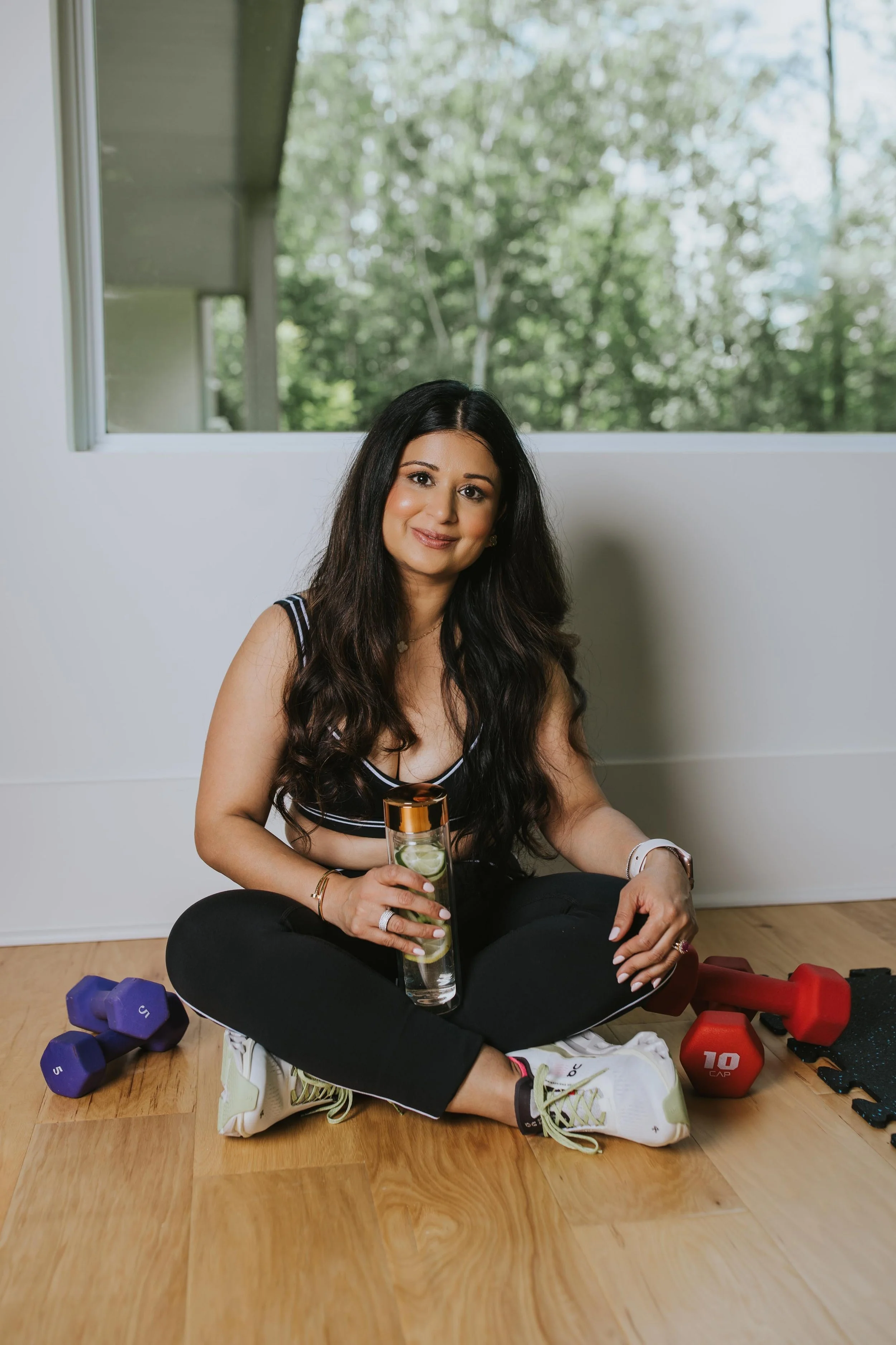 Dr. Sharma smiling in workout gear at her home gym