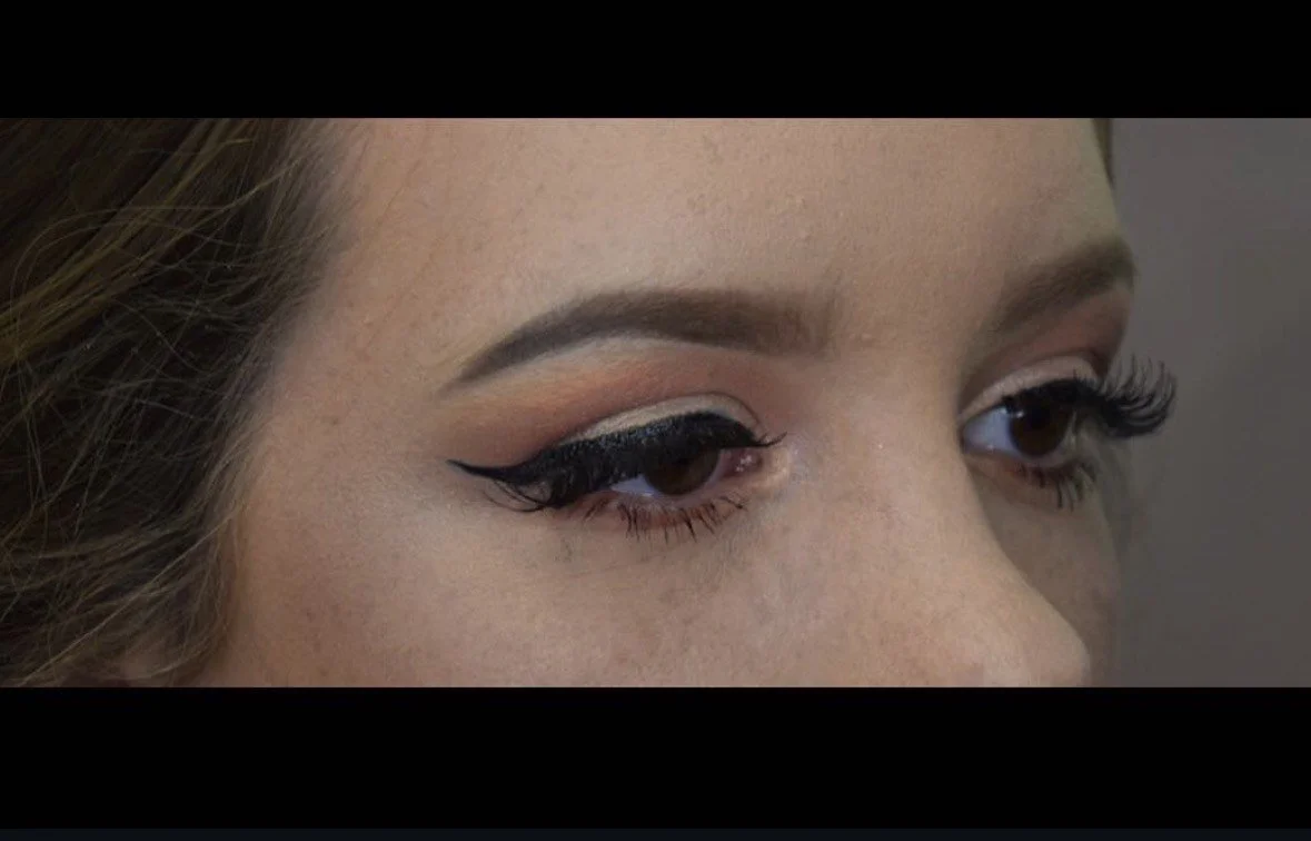 Close-up of a woman's eye with dramatic black winged eyeliner and natural makeup.