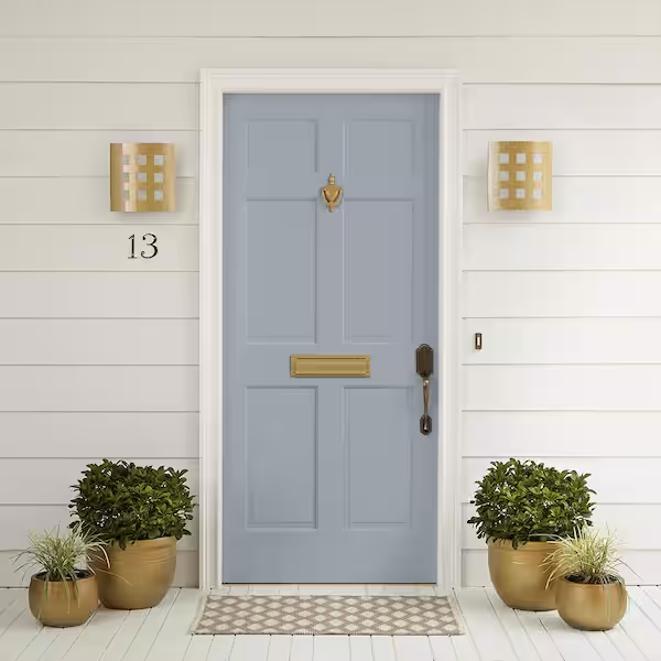Blue front door with brass hardware, house number 13, and two wall-mounted lanterns, surrounded by potted plants on either side.