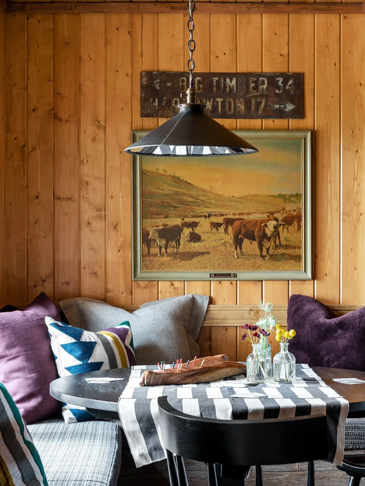 Friday Find. 

Pine panelling like this could easily feel dated, but the layering is what makes it work. The vintage road sign, the cattle painting, the mix of cushion colours that have no business working together but somehow do. It feels genuinely 