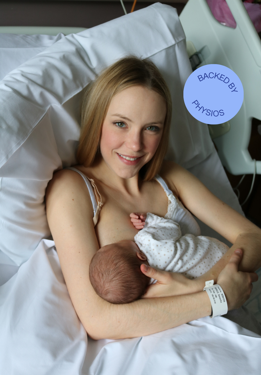 A smiling woman in a hospital bed breastfeeding a newborn baby, with a hospital wristband on her wrist and a sticker that says 'Backed by Physios'.