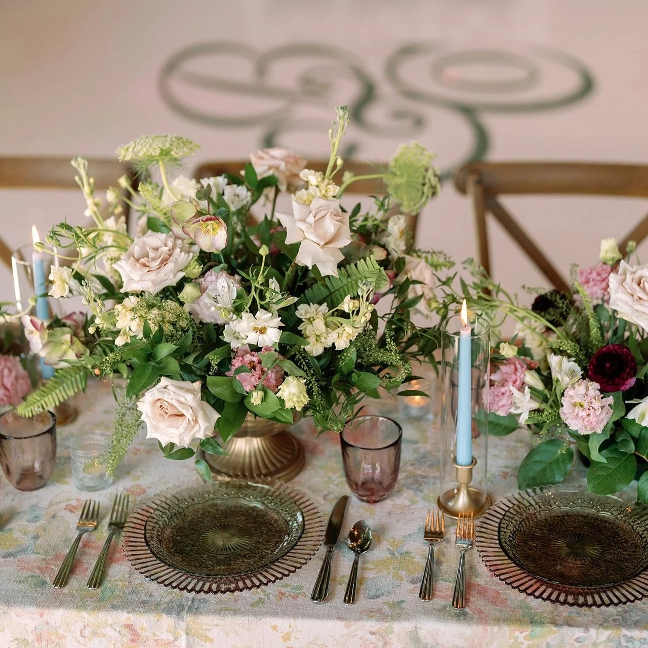Elegant table setting with a floral centerpiece, candles, and glassware for a formal dinner.