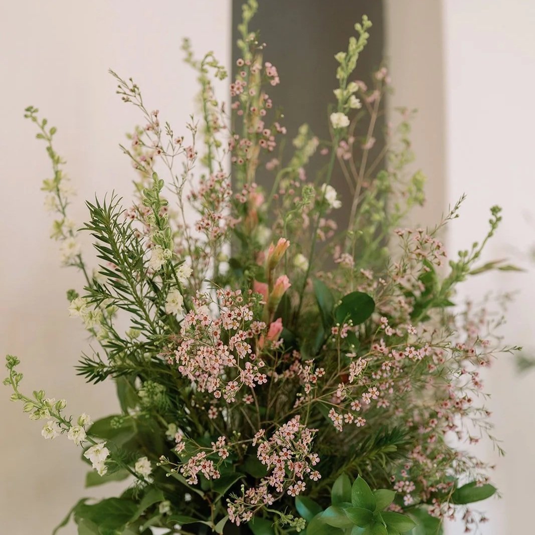 A bouquet of mixed pink and white flowers with green foliage.
