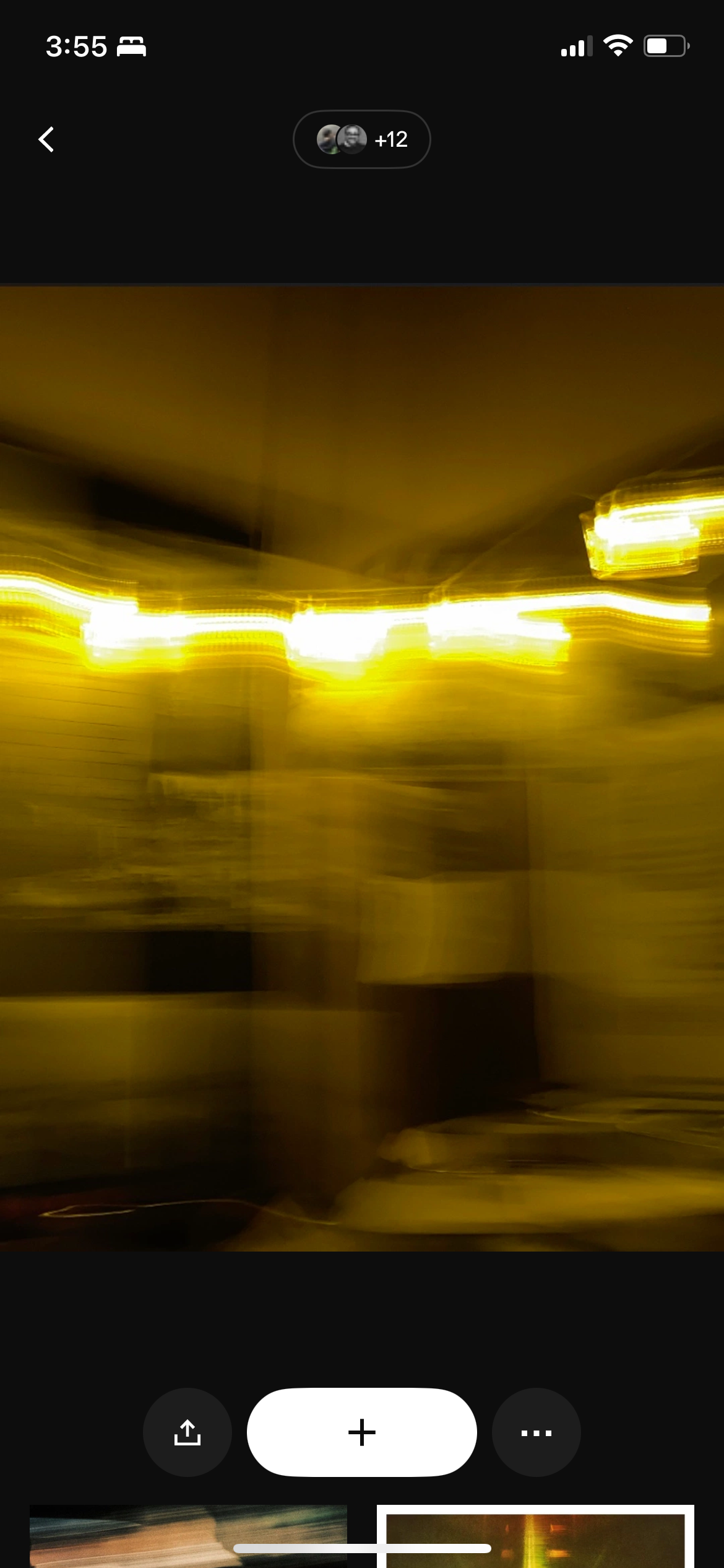 Blurred yellow string lights hanging in an interior space with tiled walls.