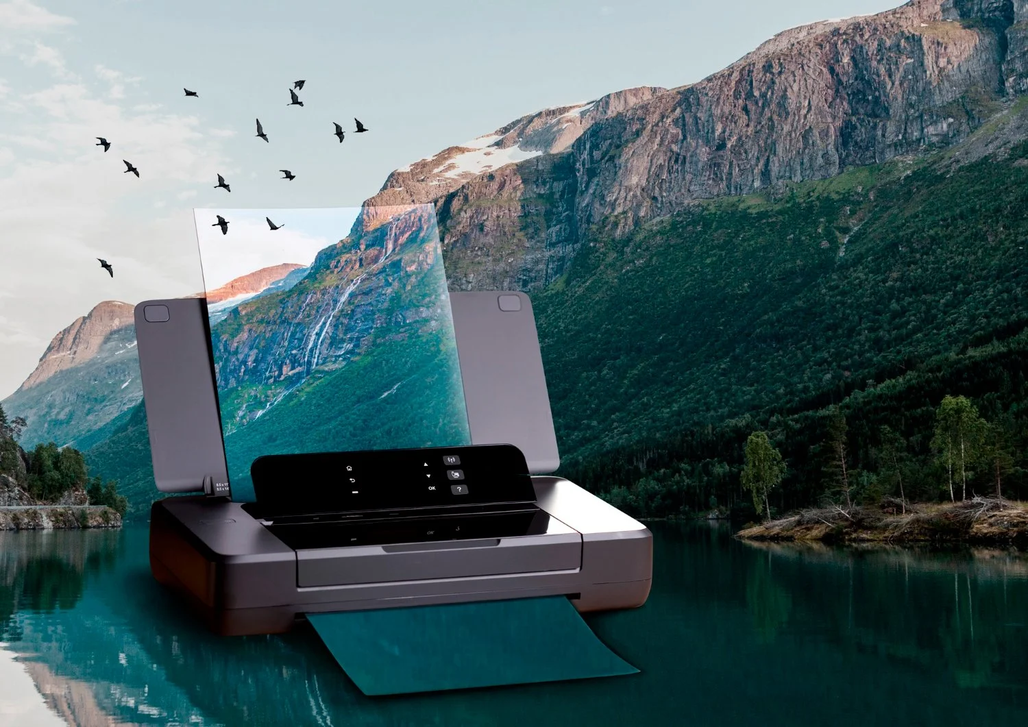 A printer with a sheet of paper in front of a scenic mountain and lake landscape, with birds flying in the sky.