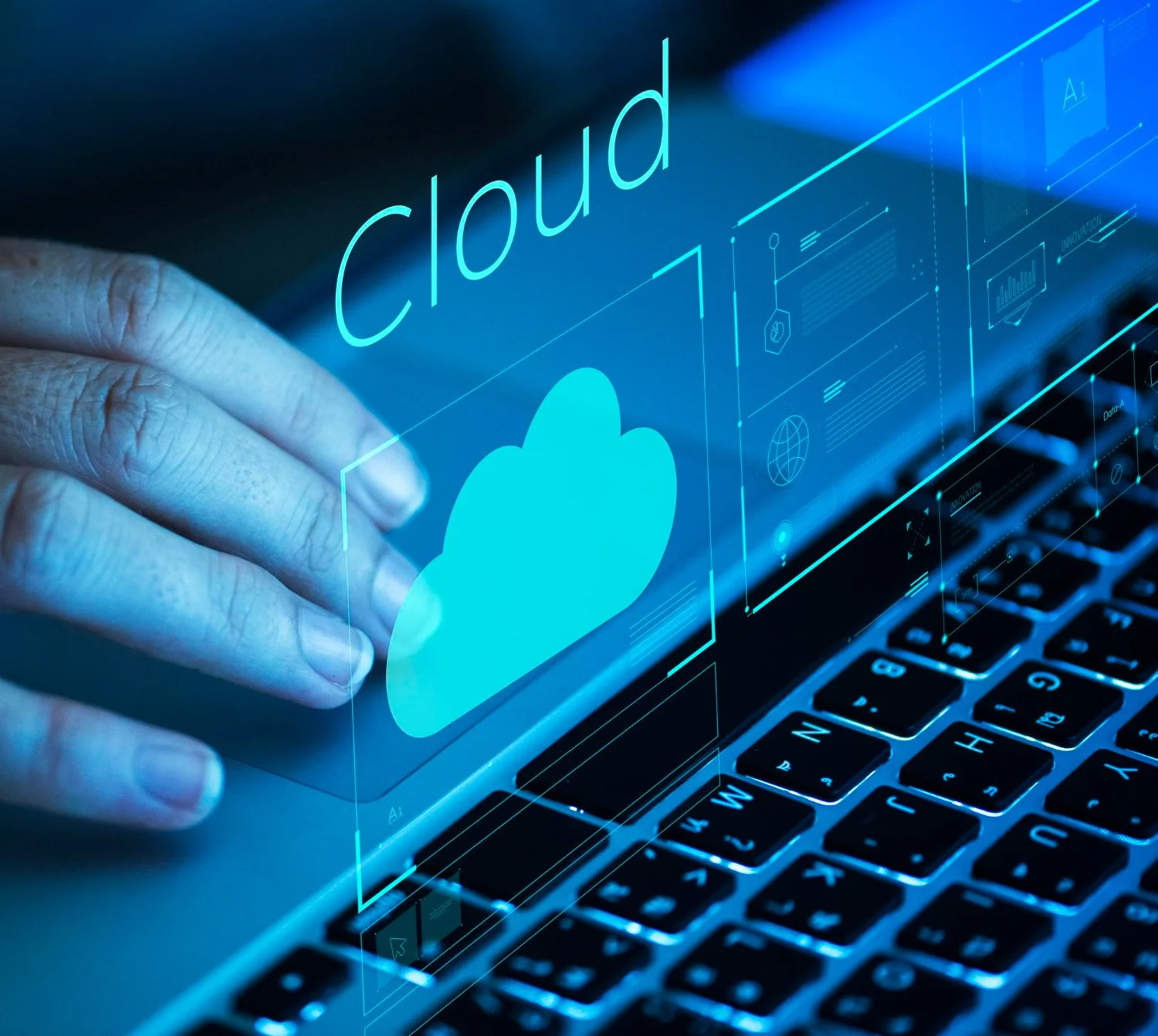 A hand touching a digital screen displaying the word 'cloud' with a cloud icon, over a laptop keyboard with illuminated keys.